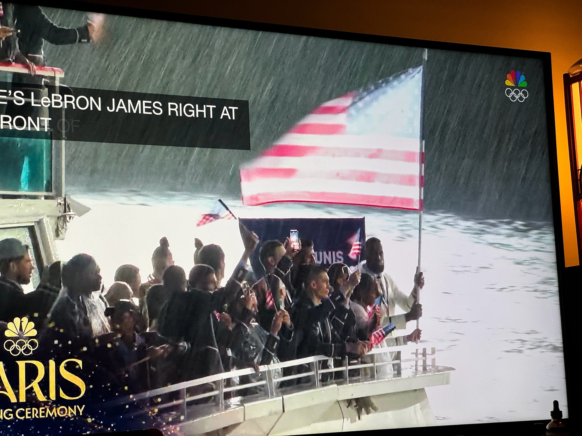 Lebron James holding the American Flag, on a boat in the Seine