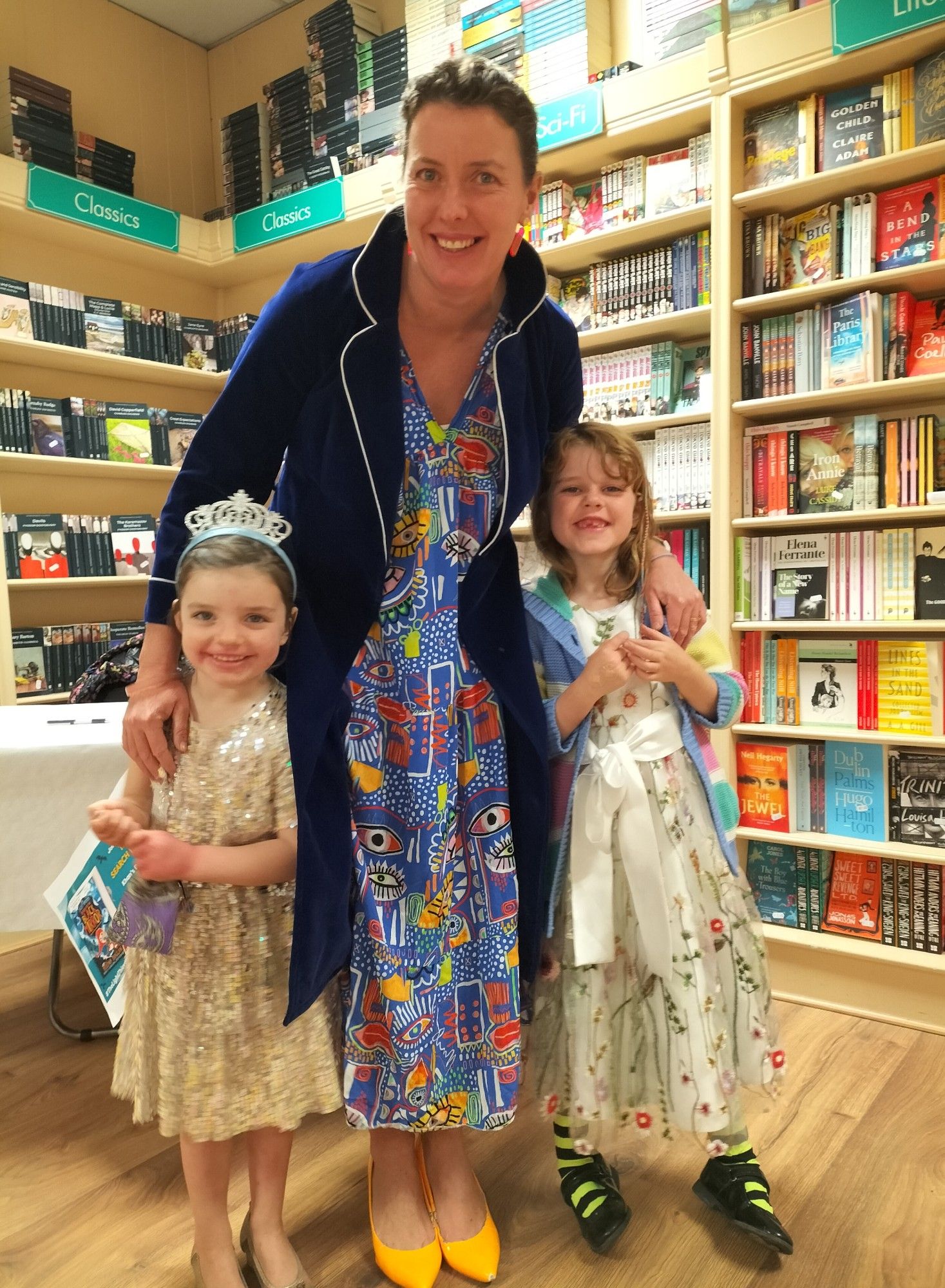 A photo of author Helena Duggan all dressed up with her young daughters at her book launch in Khan's Bookshop in Kilkenny City, Ireland