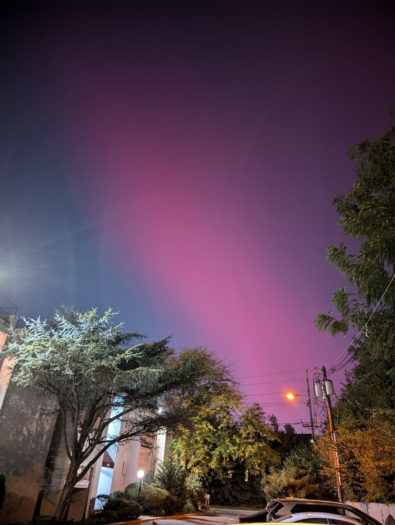 A red streak of an Aurora across the sky above my apartment in New Jersey with all the lights on and the sky just barely dark