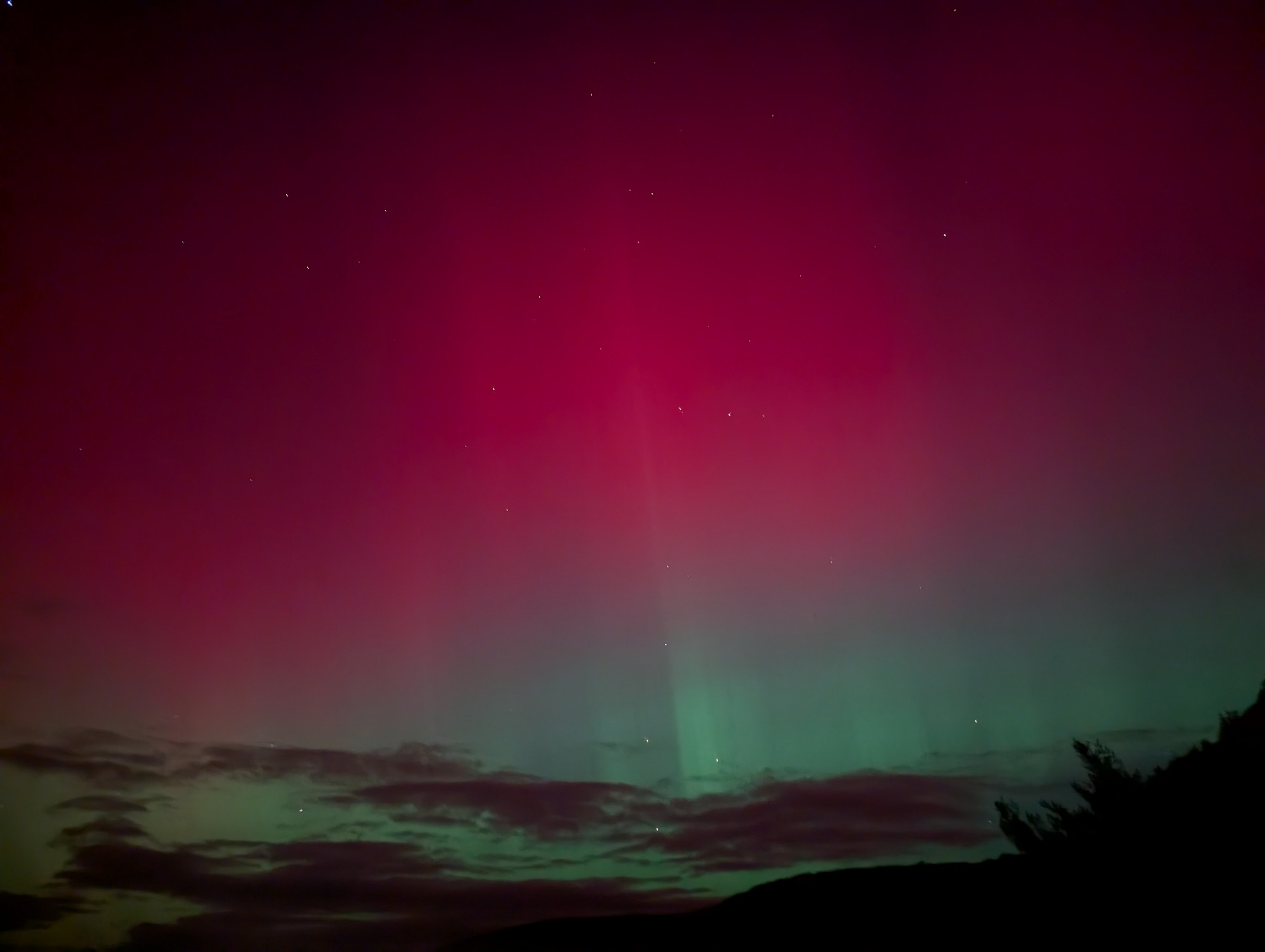 A red and green night sky with some clouds