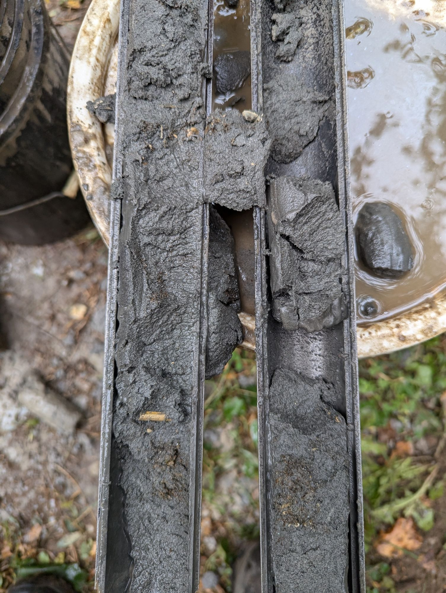 Gray silty sand with some peat in an open split spoon sampler