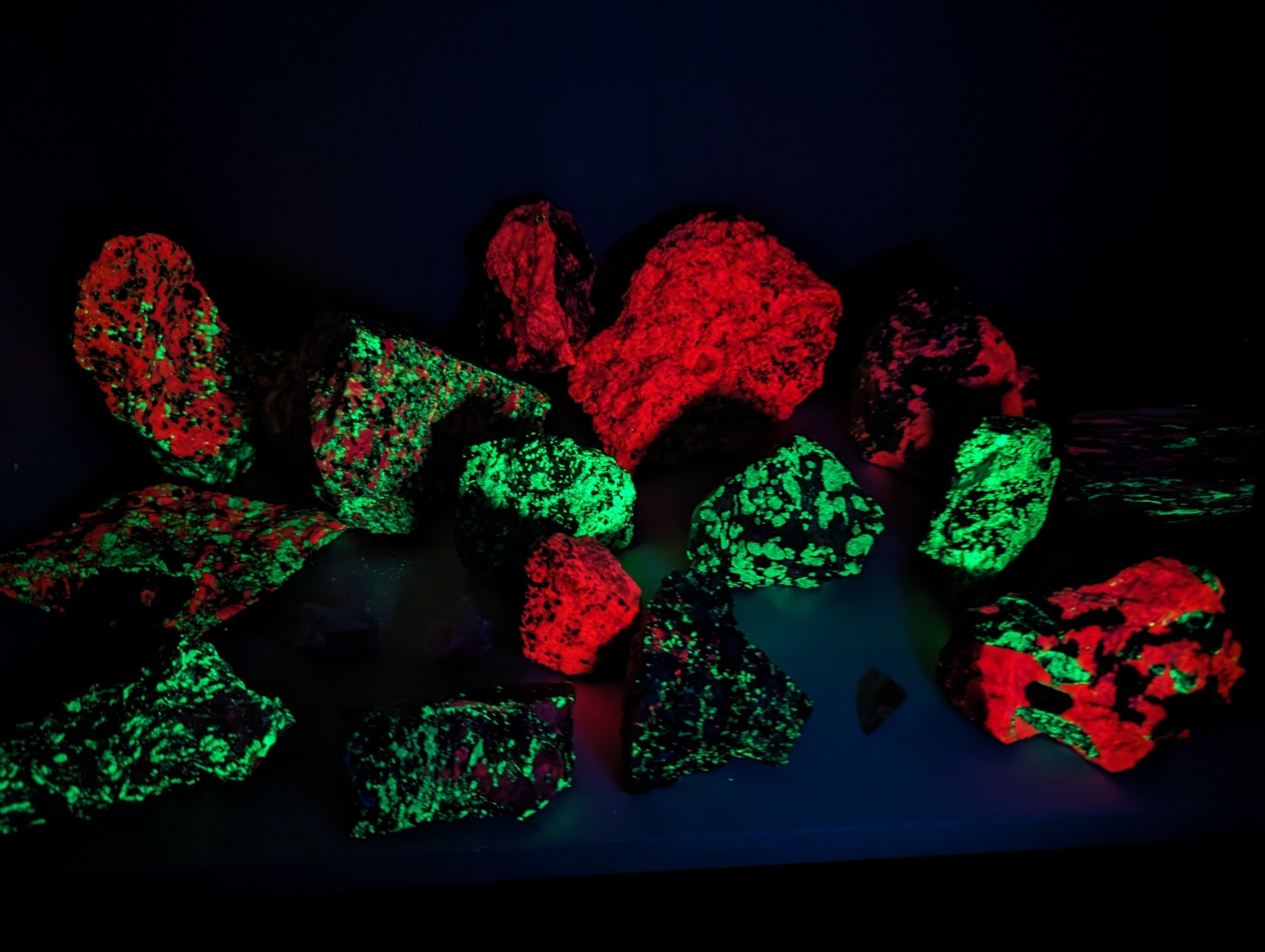 A bunch of rocks from Franklin, NJ glowing red and green under uv light