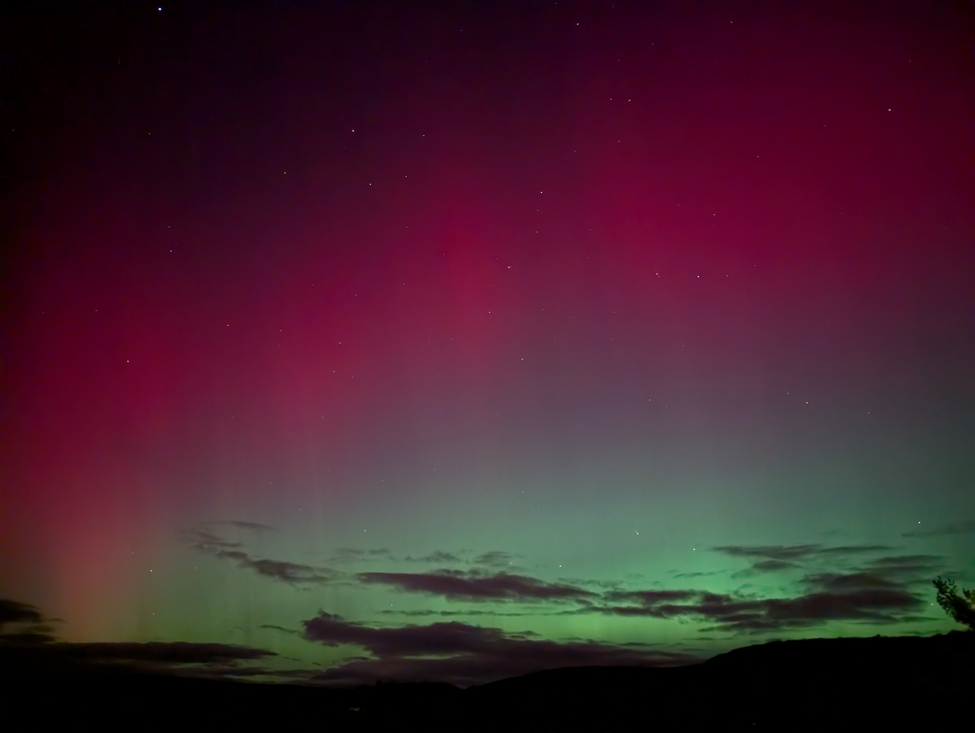 A red and green night sky with some clouds