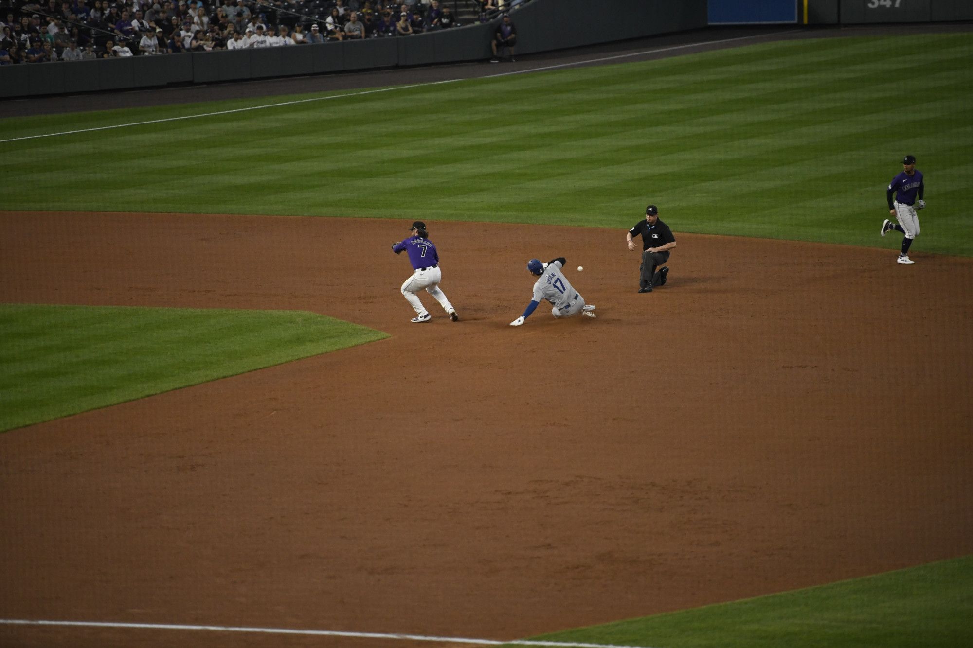 Ohtani stealing second base, as the baseball thrown by the catcher misses the intended target and goes past Ohtani.