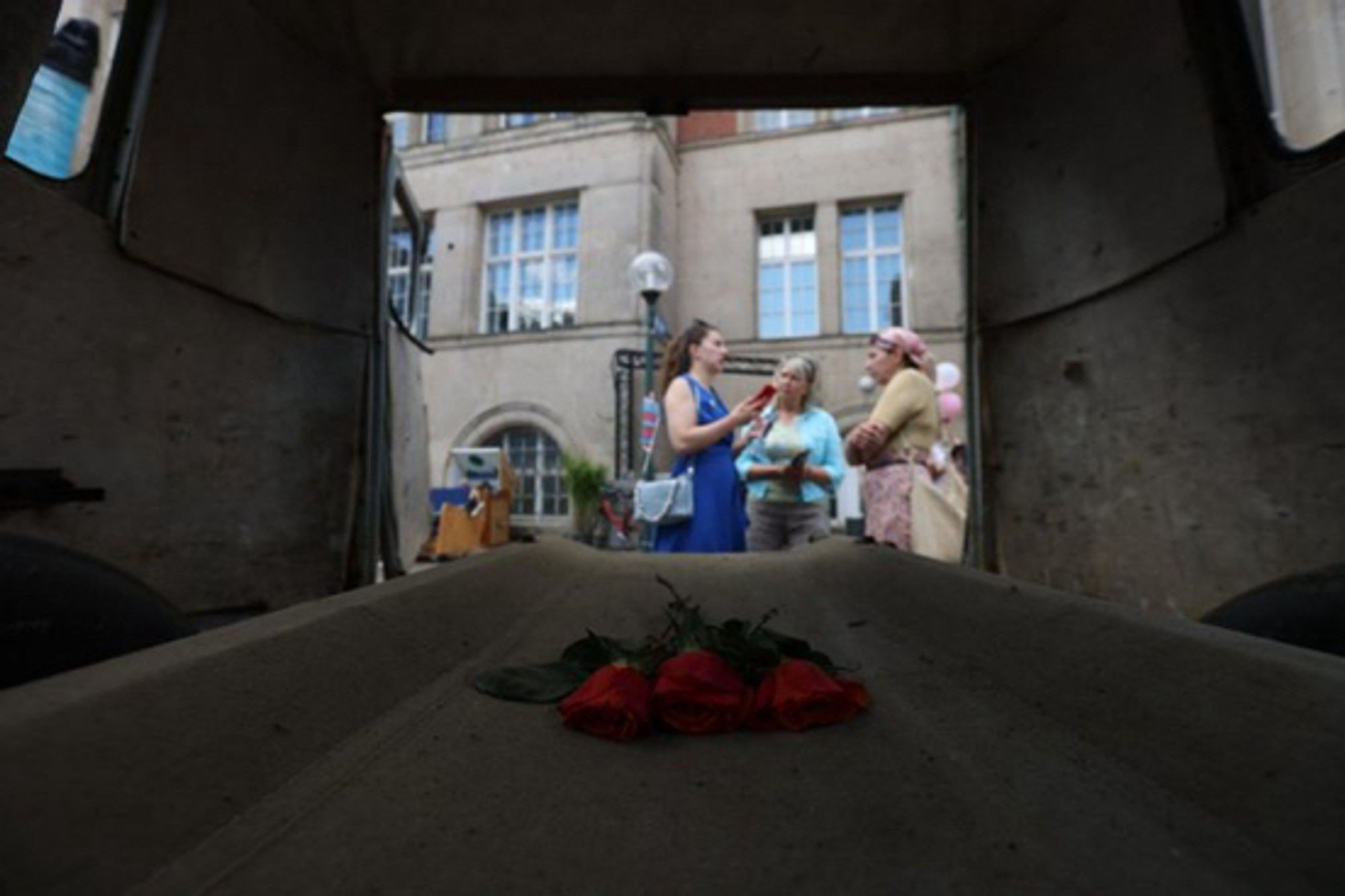 Blick durch die Heckklappe auf eine Gruppe diskutierender Frauen