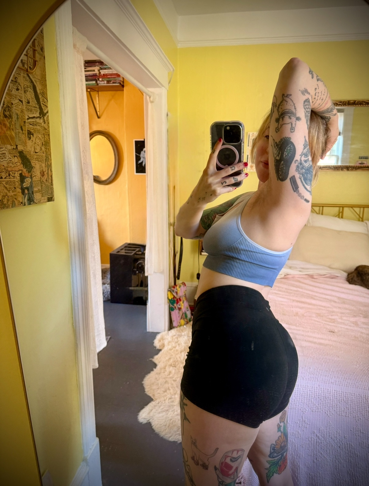 Tattooed blonde taking a mirror selfie in workout clothes