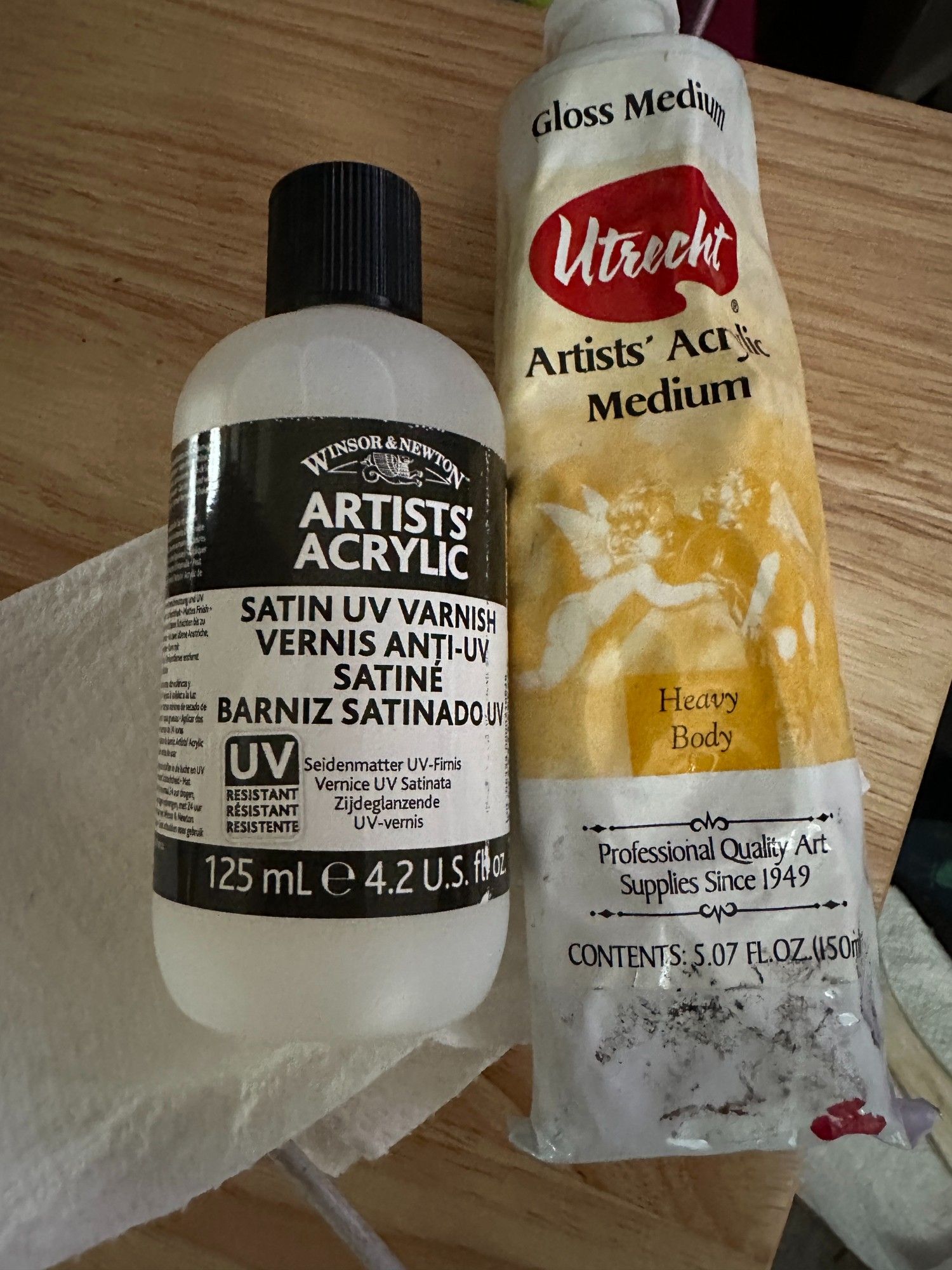 A pic of Winsor & Newton’s acrylic satin UV varnish next to a tube of Utrecht’s gloss medium.