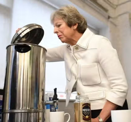 Theresa May looking into an urn