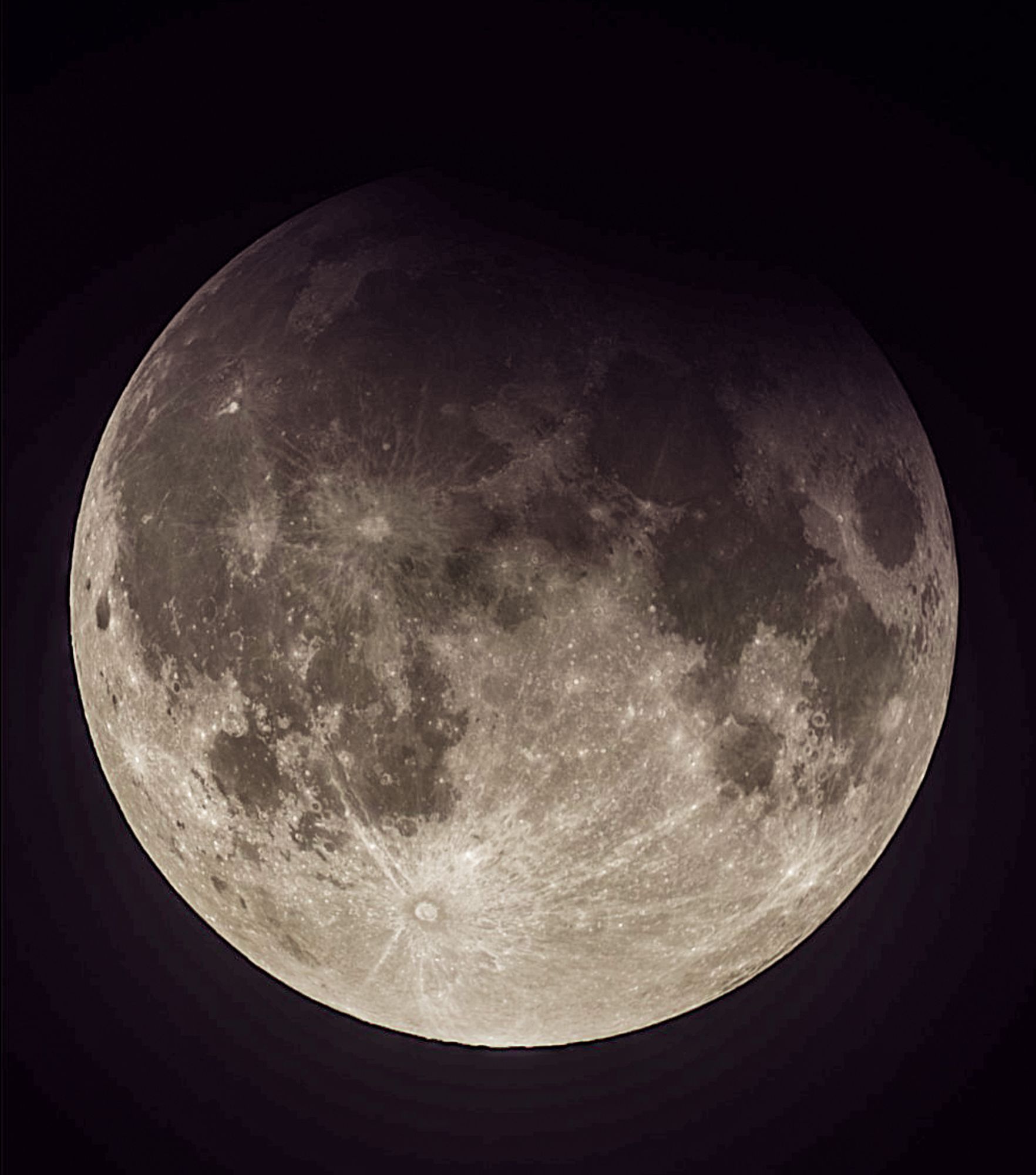 Photo of full moon during partial eclipse. Tycho ray crater is prominent at about 7 clock position. From about 11 to 2 clock position, the top of the visible moon is darkened by Earth's shadow.