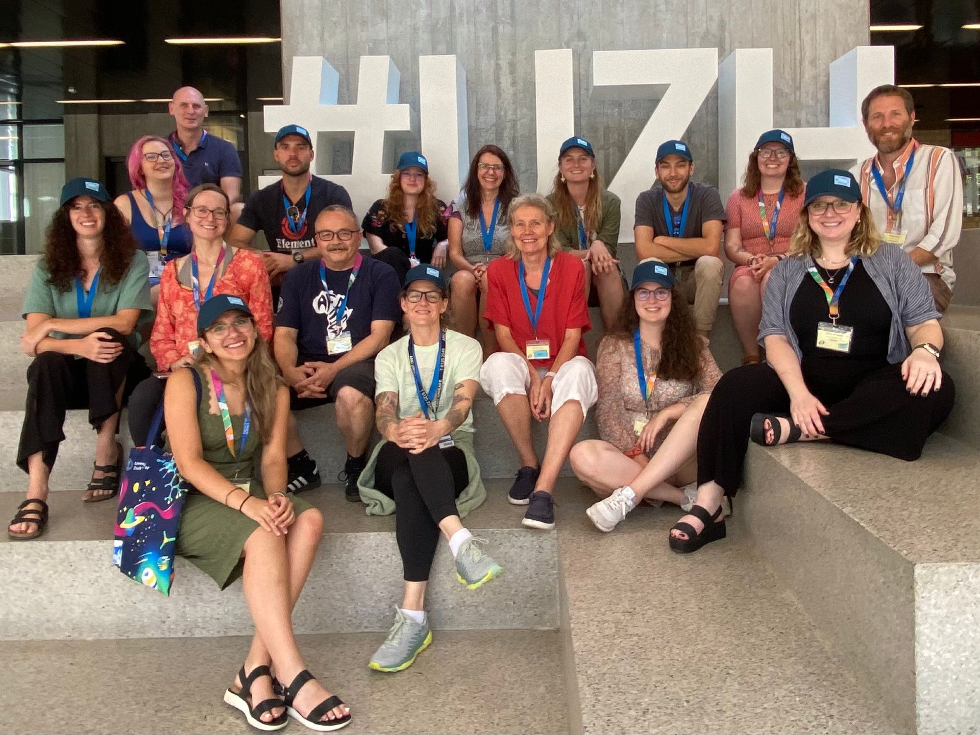 Volunteers with the UZH sign on the stairs.