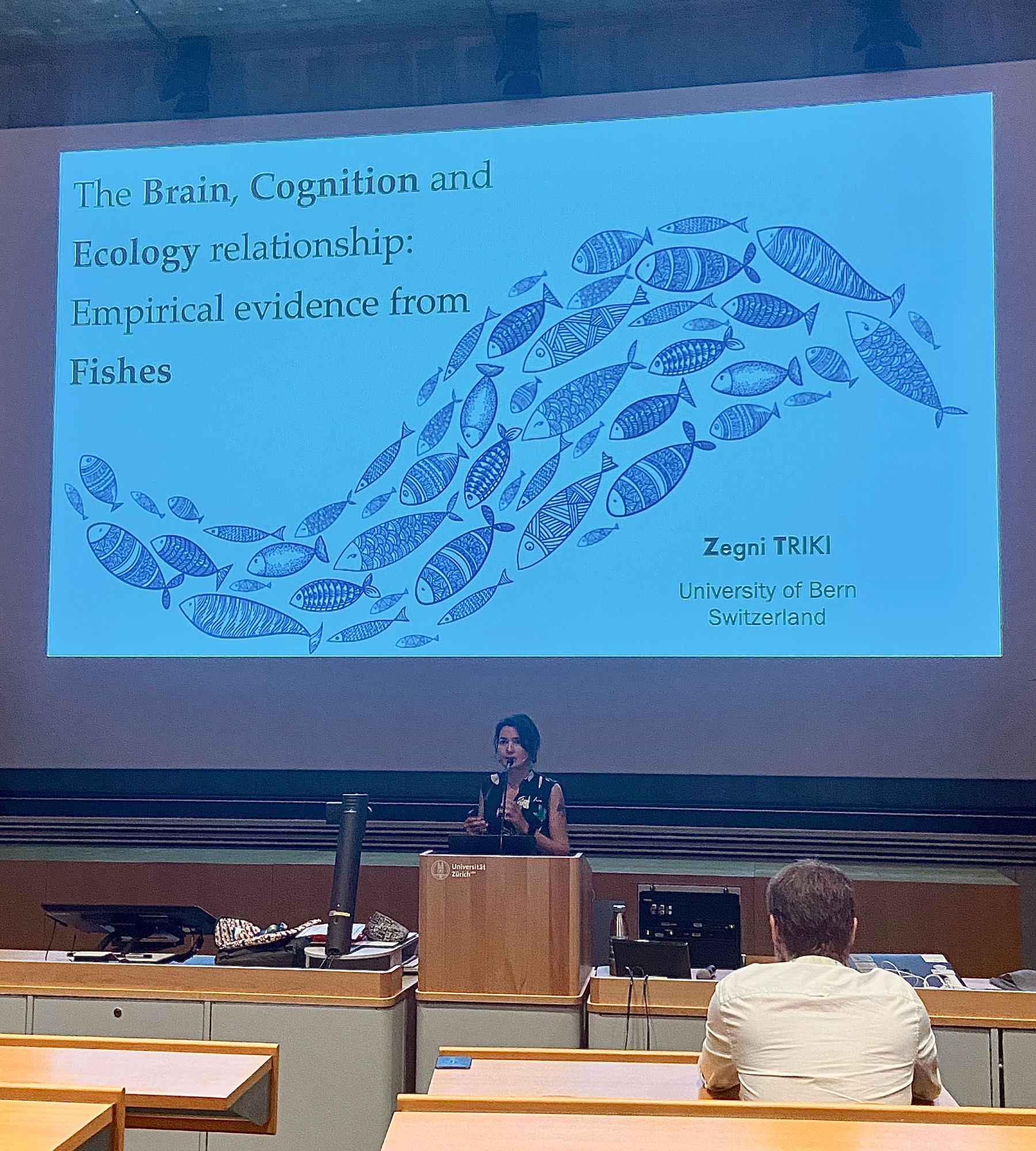 Zegni Triki at the lectern with a slide reading “The brain cognition and ecology relationships: empircal evidence from fishes” Zegni triki university of bern switzerland