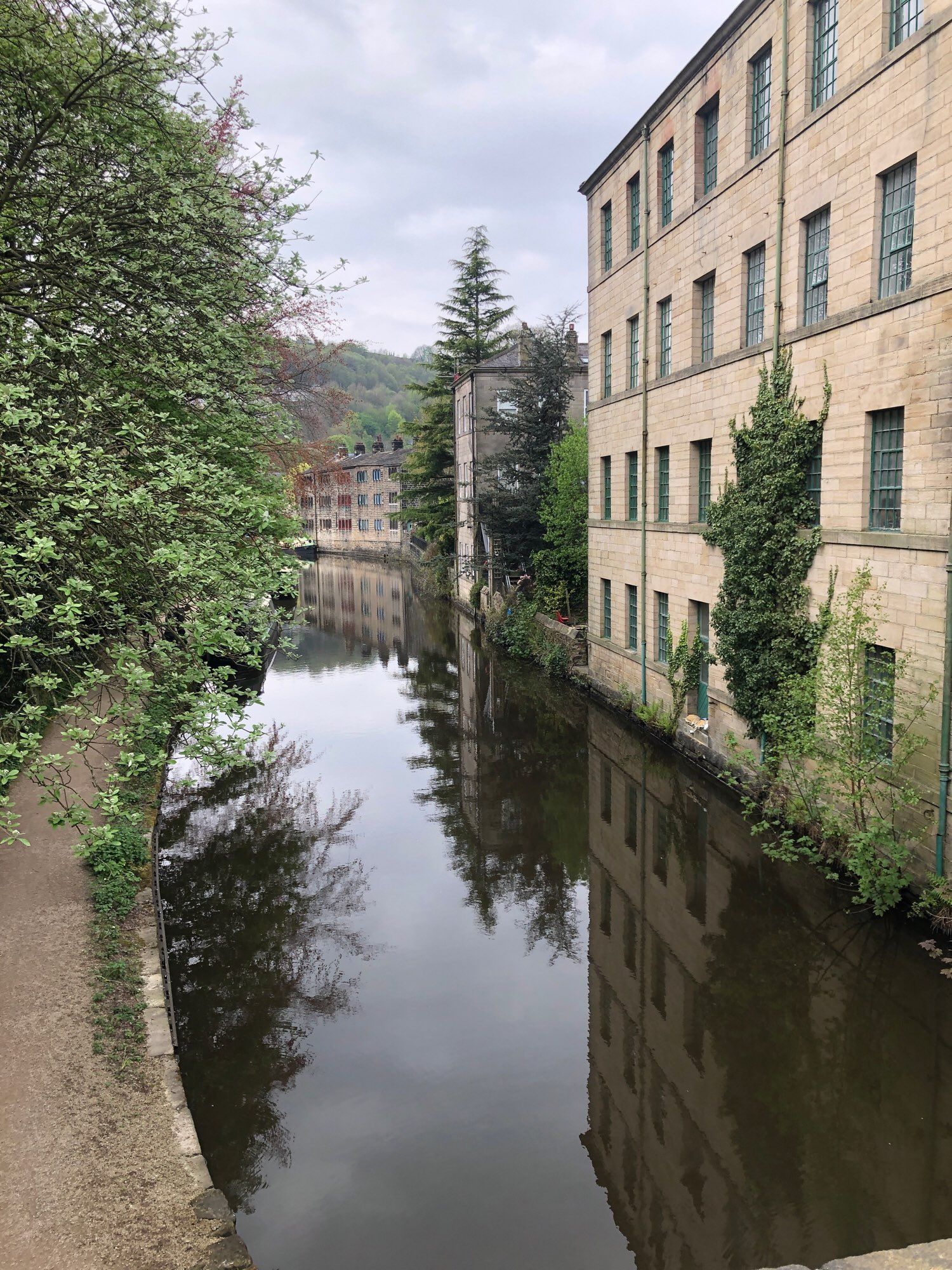 The canal at Hebden Bridge. An old mill is reflected in its still, calm waters.