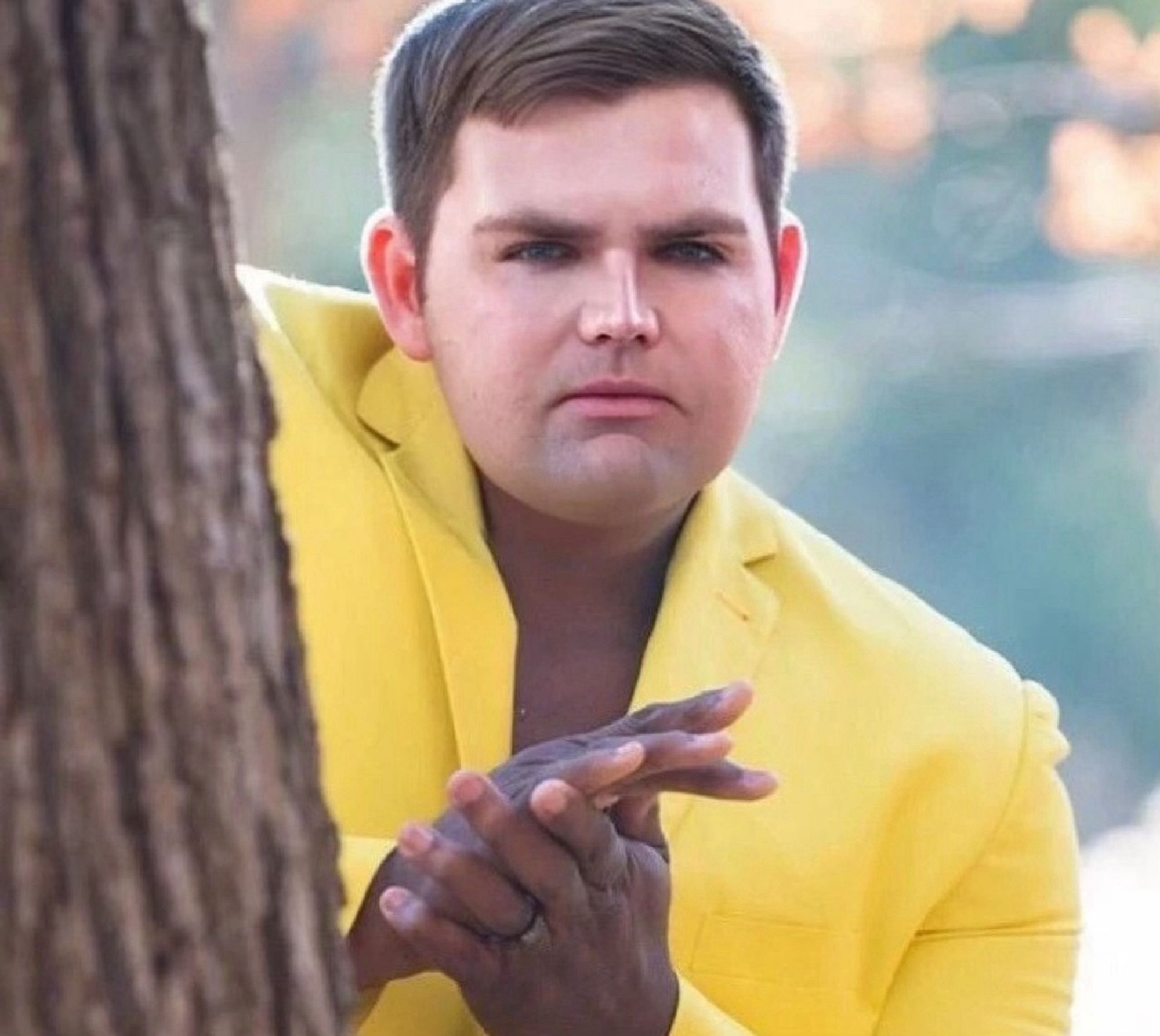 JD Vance hiding behind a tree rubbing his hands