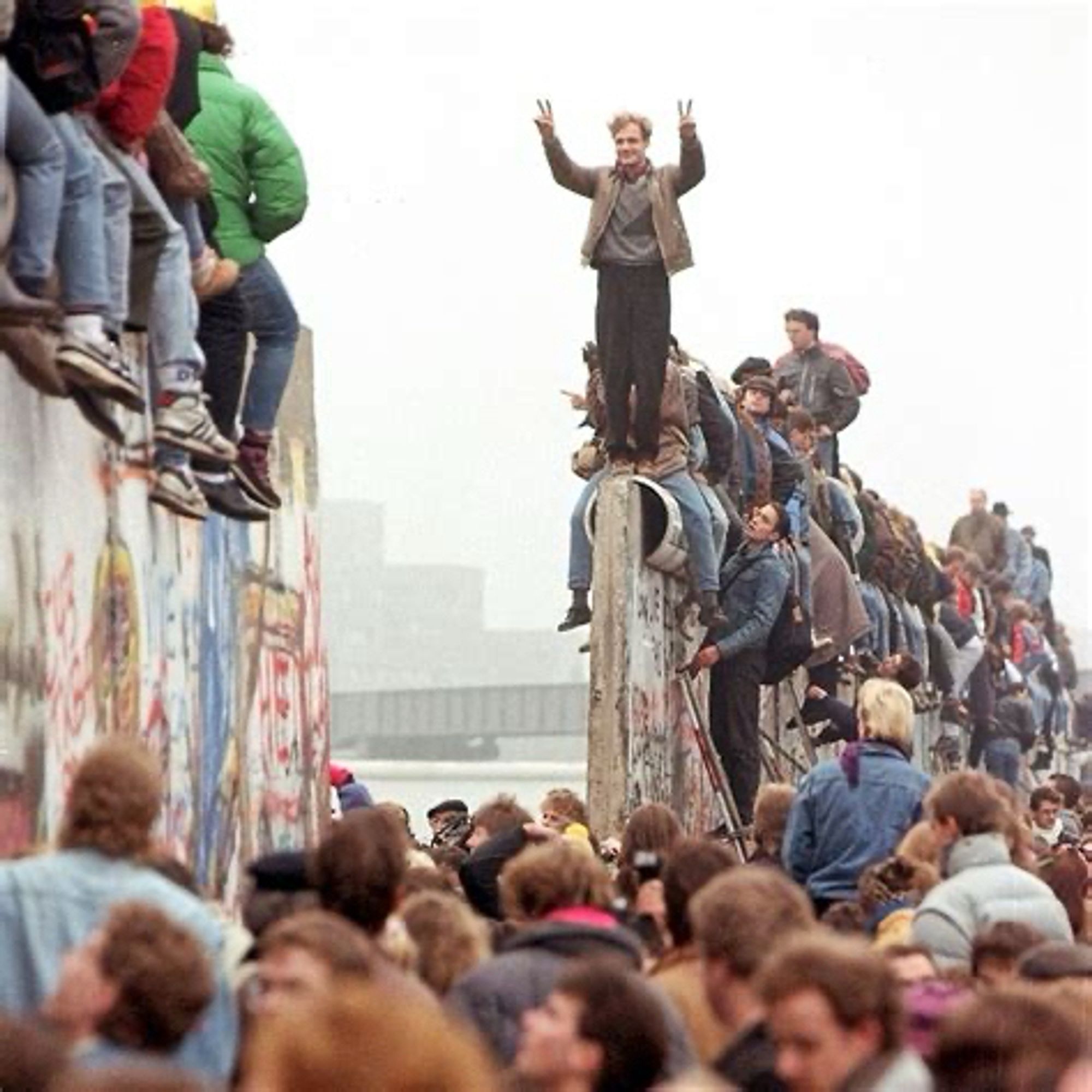 Berlin Wall, huge gaping hole in the middle of it people walking through