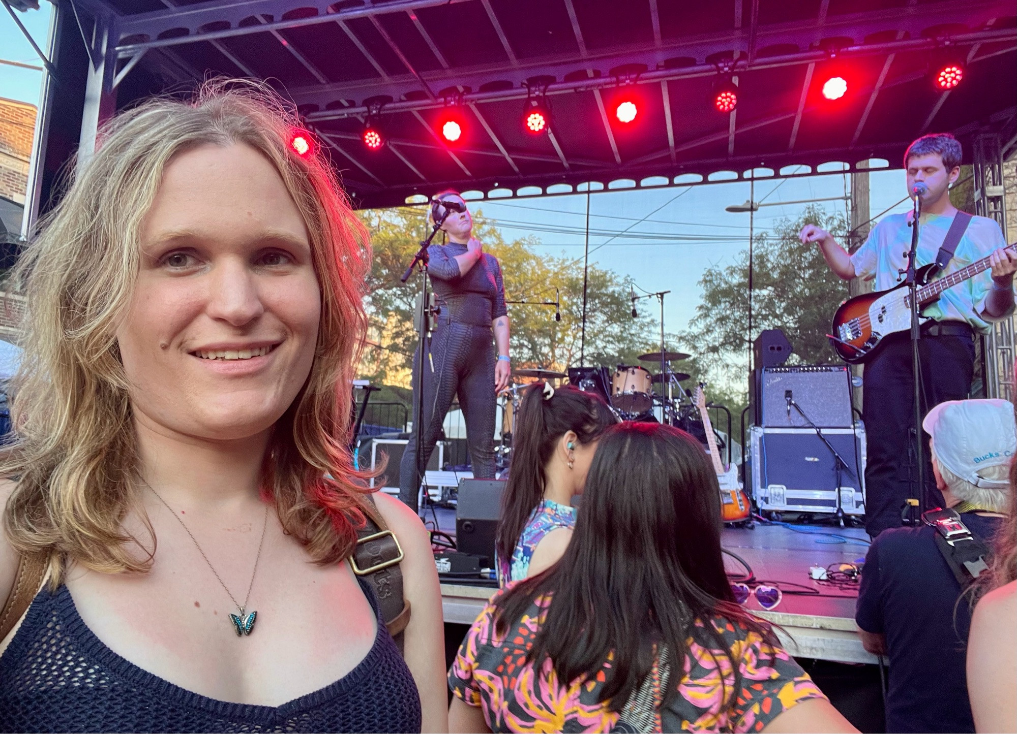 A middle aged blonde woman with sunburn stands in front of a stage