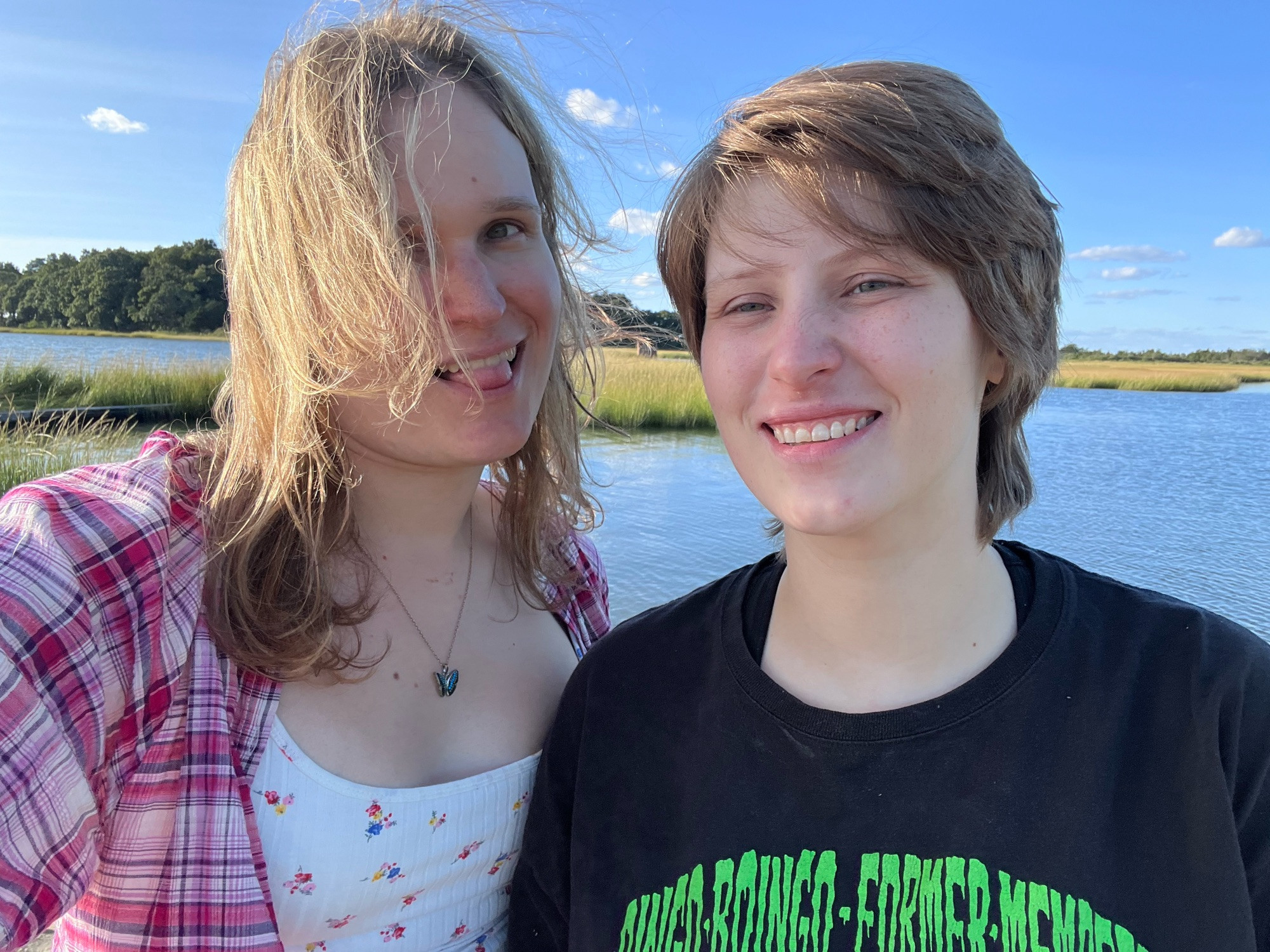 Two women standing in front of a body of water