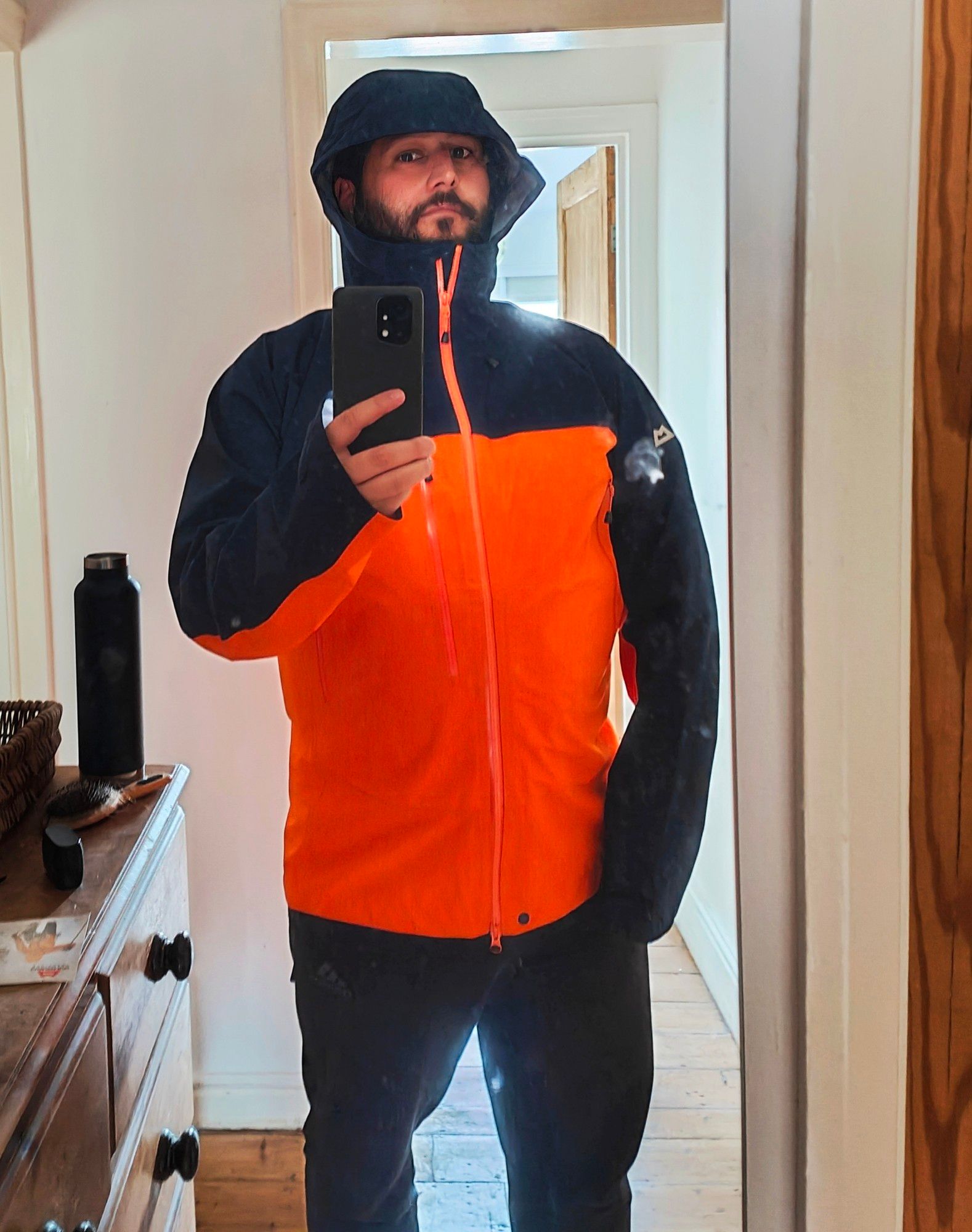 Me standing in my landing for a mirror shot wearing a papaya and black Mountain Equipment Makalu jacket.