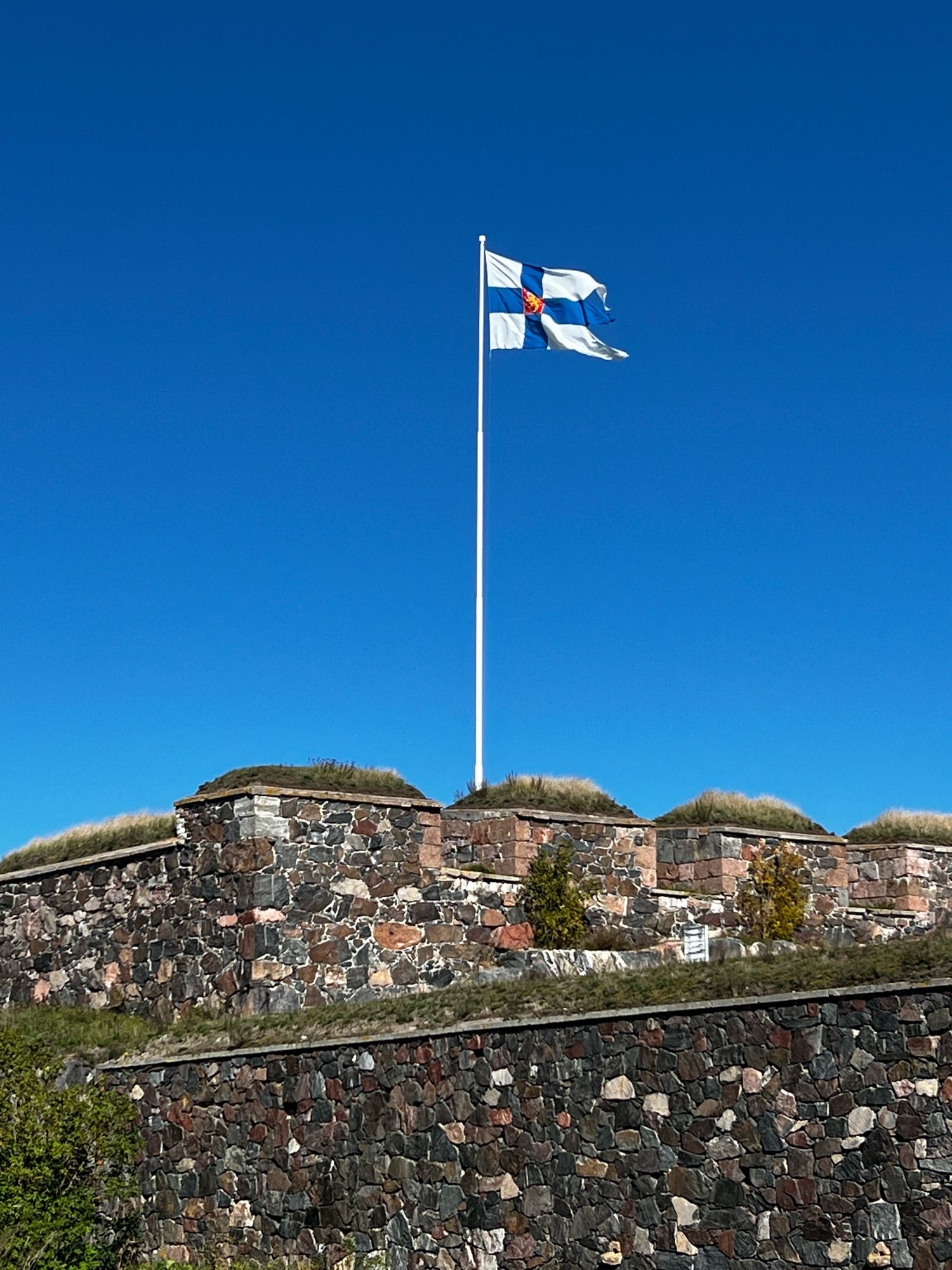 Finská vlajka v modré obloze na Suomenlinně.