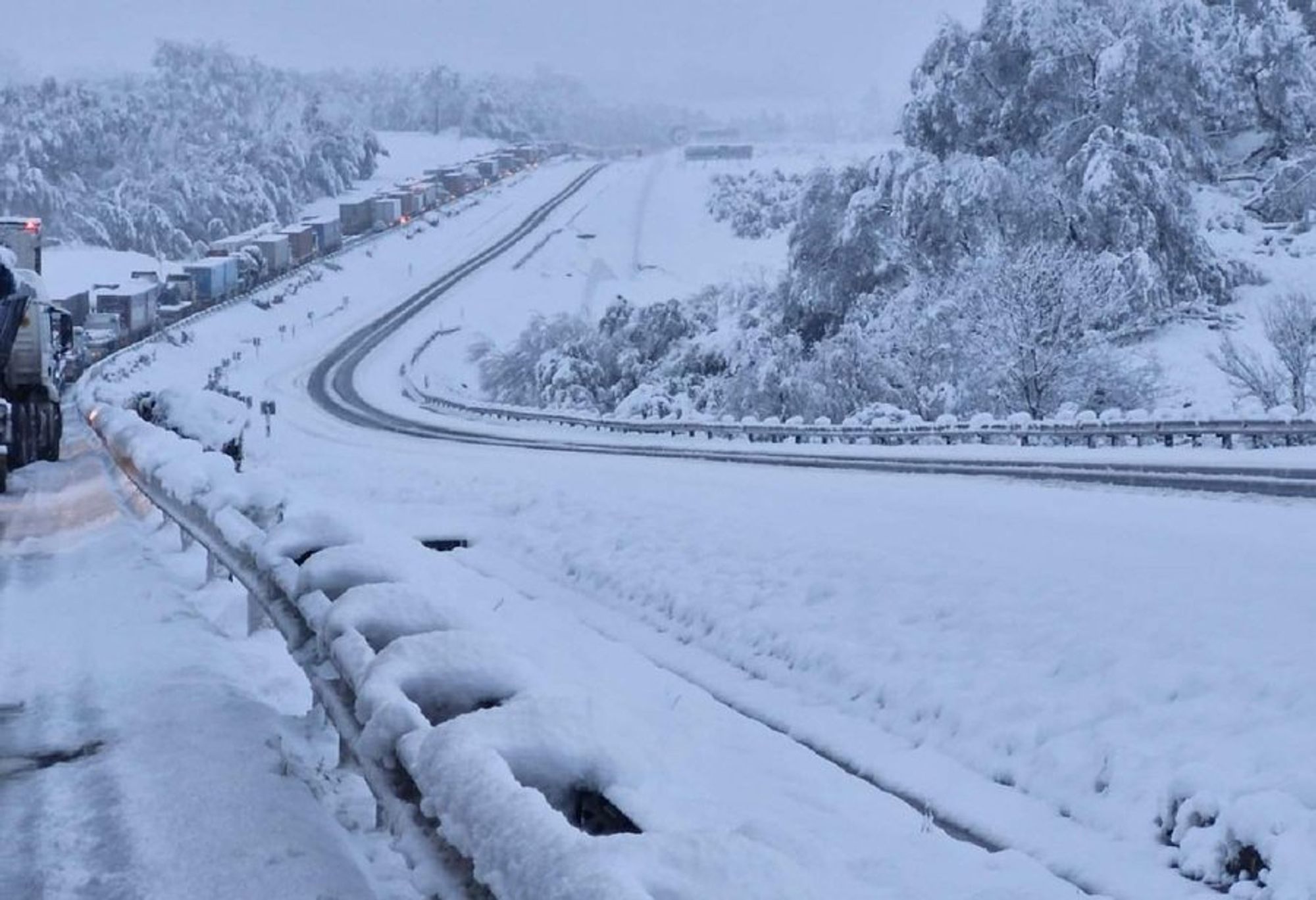 long line of trucks stuck in heavy snow at Van Reenen's pass in KZN, S.Afr