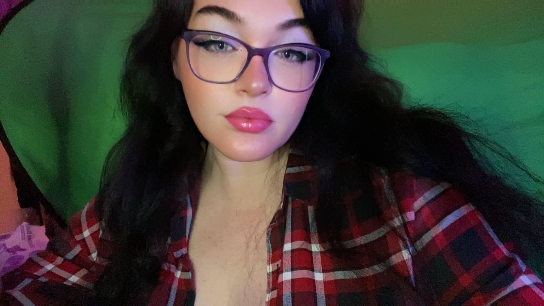 A picture of me in glasses in front of a broken green screen 