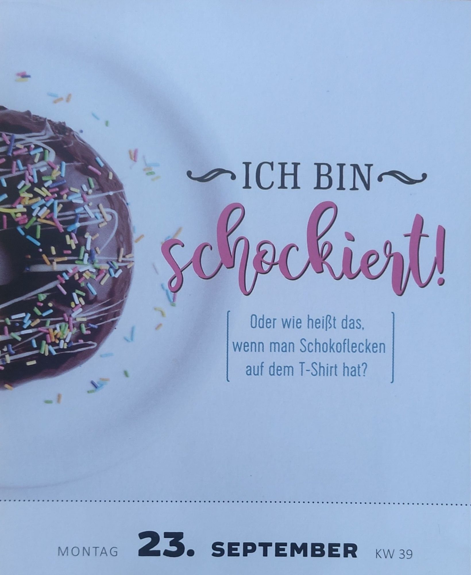 Kalenderblatt vom 23. September: 
Ich bin schockiert! Oder wie heißt es, wenn man Schokoflecken auf dem T-Shirt hat?

Links daneben ein halber Schokoladen-Donut