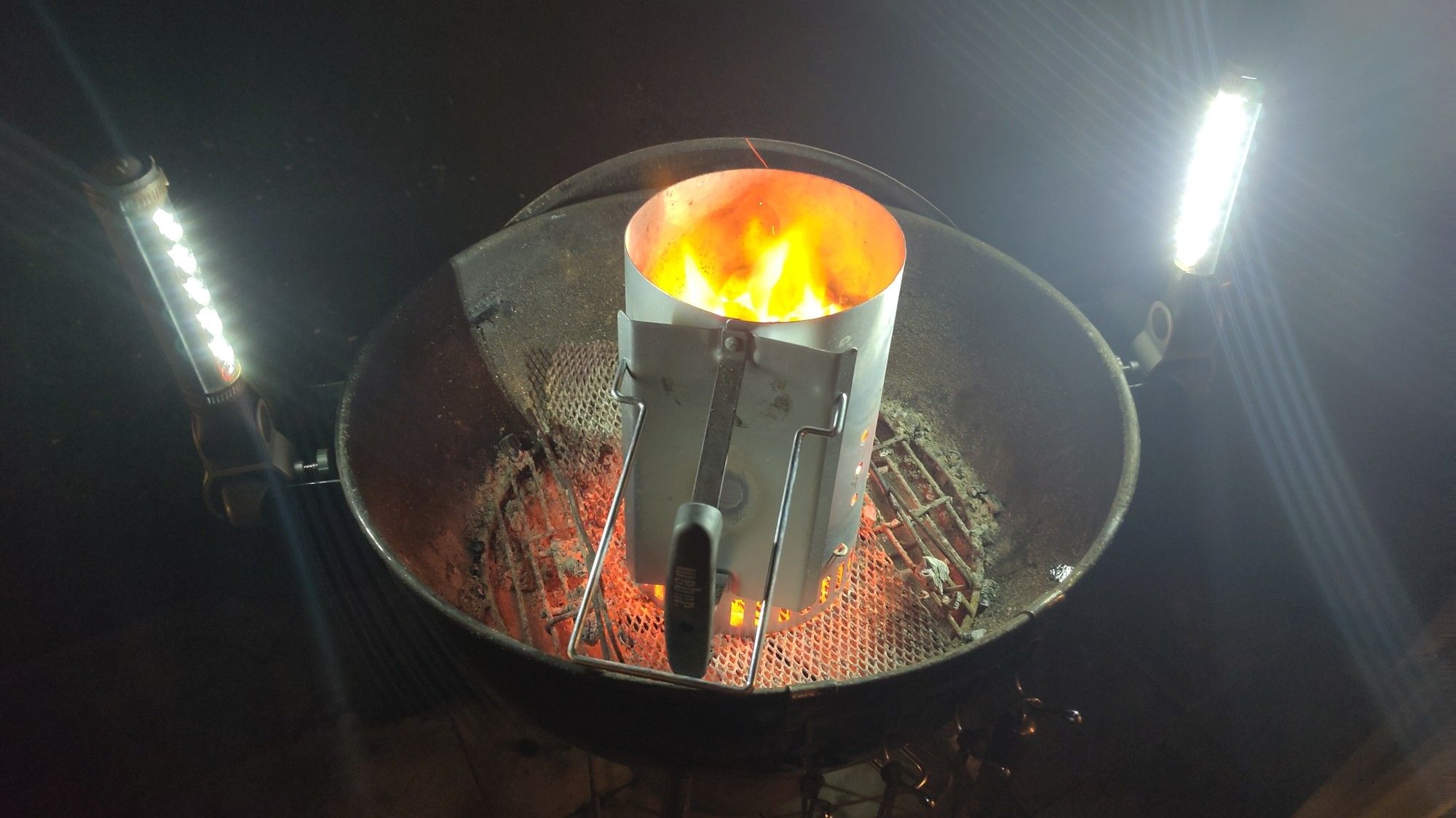 Anzündkamin mit duechgeglühten Grillbriketts im Kugelgrill stehend