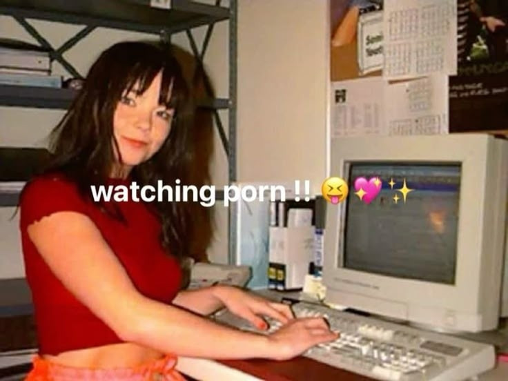 photo of björk sitting at a computer with the  text saying "watching porn!"