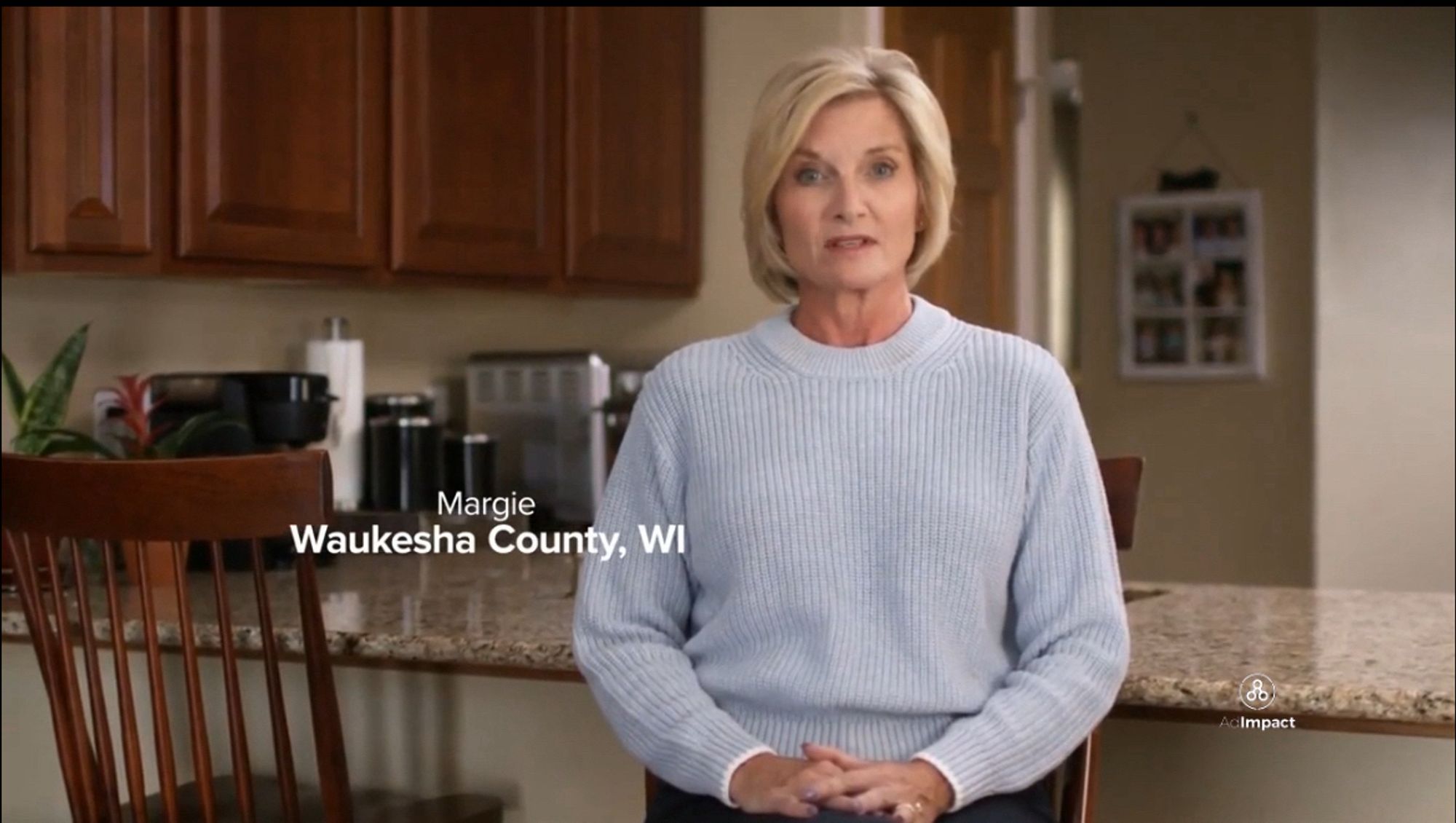 “Margie from Waukesha County, WI”, an older middle-aged white woman with a blunt, blonde haircut and wearing a light blue sweater, sits in her beige kitchen