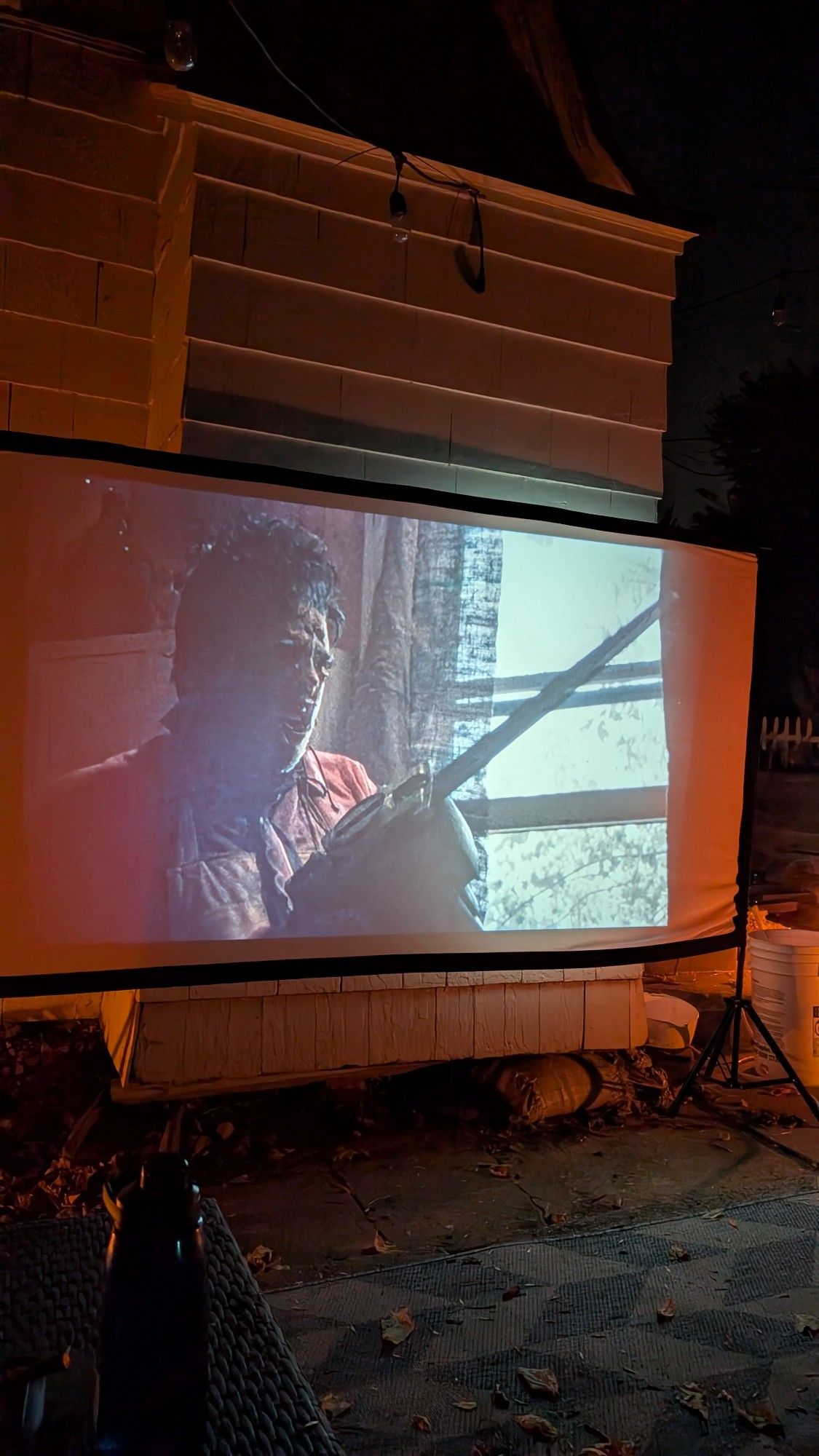 Leatherface with a chainsaw on a backyard projector. 