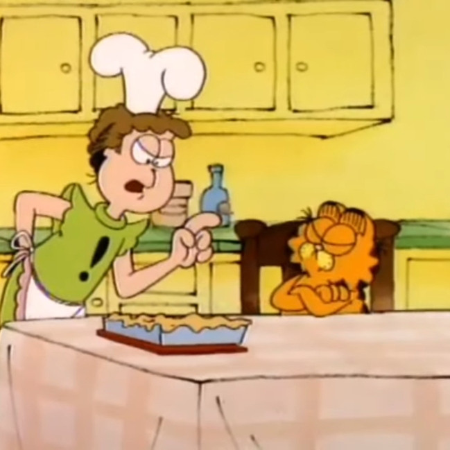 A picture of Jon Arbuckle wearing a sleeveless green shirt with an exclamation point, an apron, and a chef's hat looking angrily at Garfield the cat. A disgusting looking beige pile of slime that is supposed to be a lasagna sits in between them.