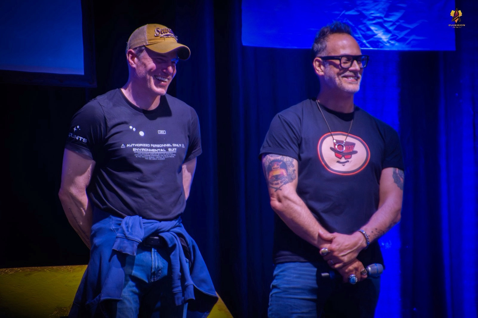 Actors Anson Mount and Todd Stashwick standing next to each other during FedCon 32 in Bonn, Germany. Both men are grinning