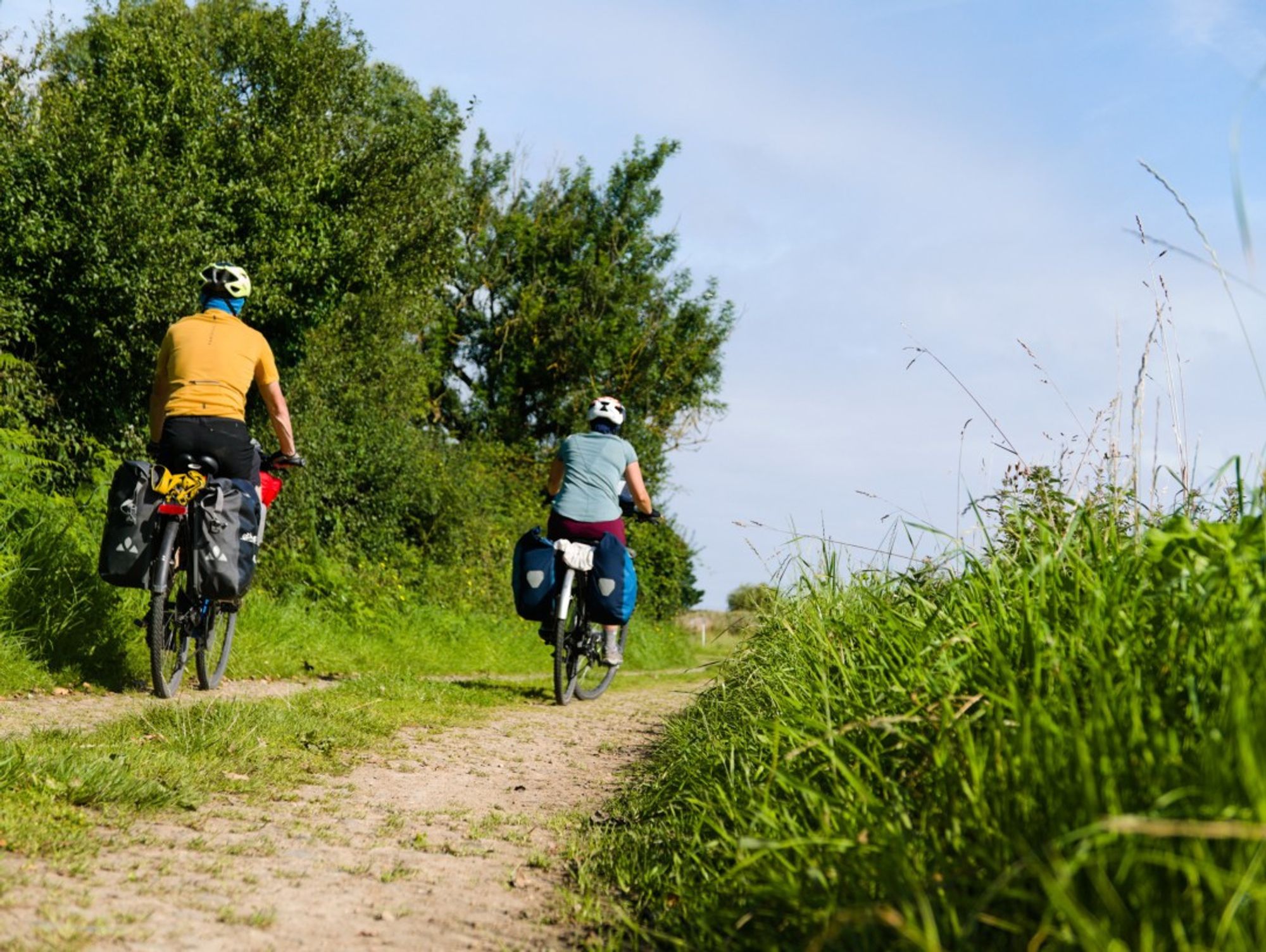 deux cyclotouristes sur un chemin de terre le long de la Vélomaritime un itinéraire cyclable