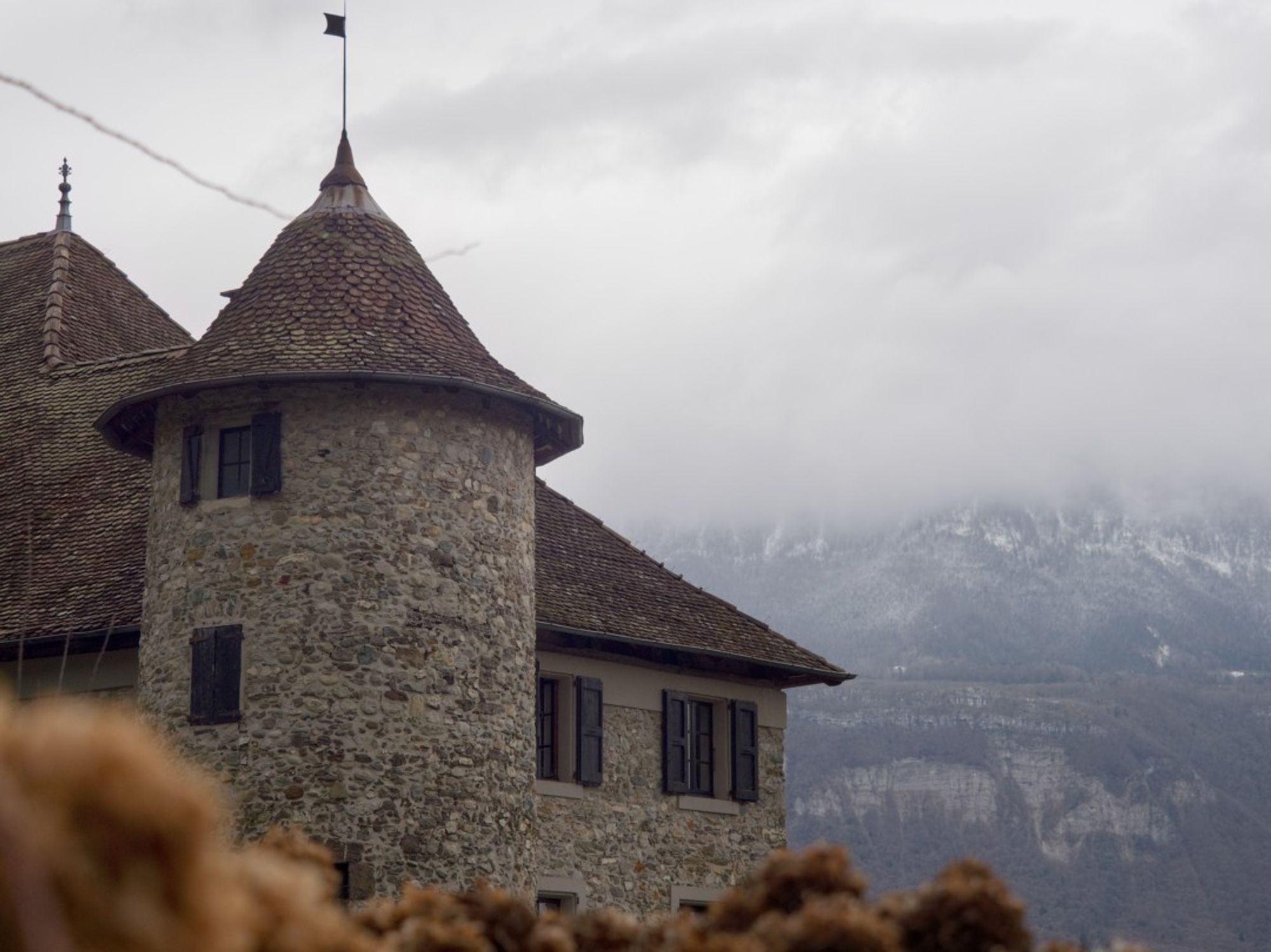 maison dauphinoise avec le massif de la chartreuse caché par les nuages