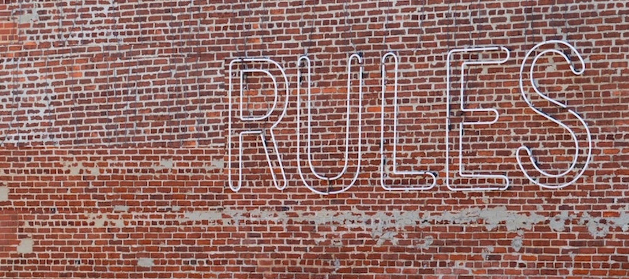 brick wall with the word rules on it.