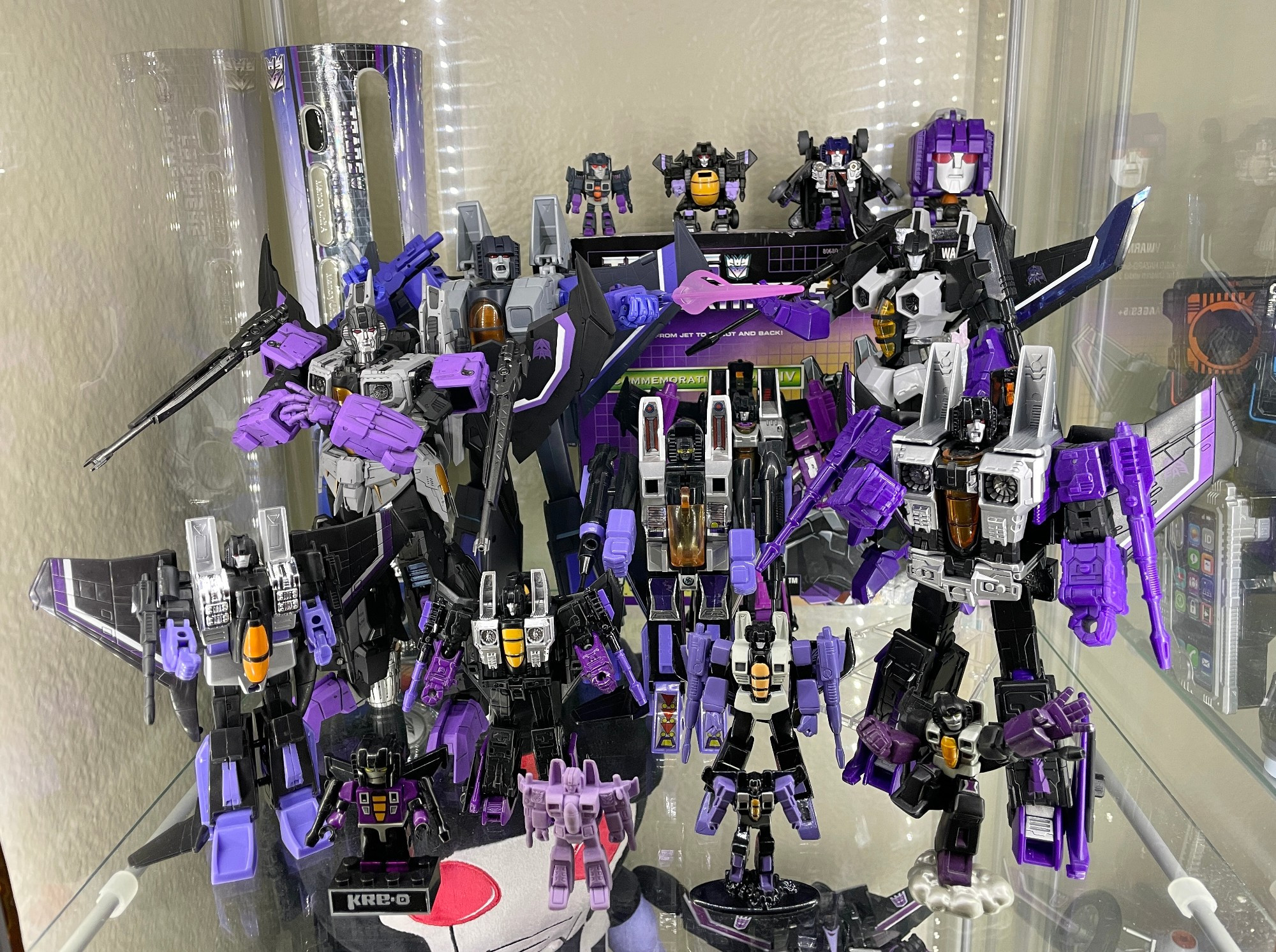 A display shelf full of Transformers Skywarp figures. Got the G1 lad in there, Classics, Earthrise, the most recent Masterpiece, the new threezero one... and a few more, all based on Skywarp's G1 look.