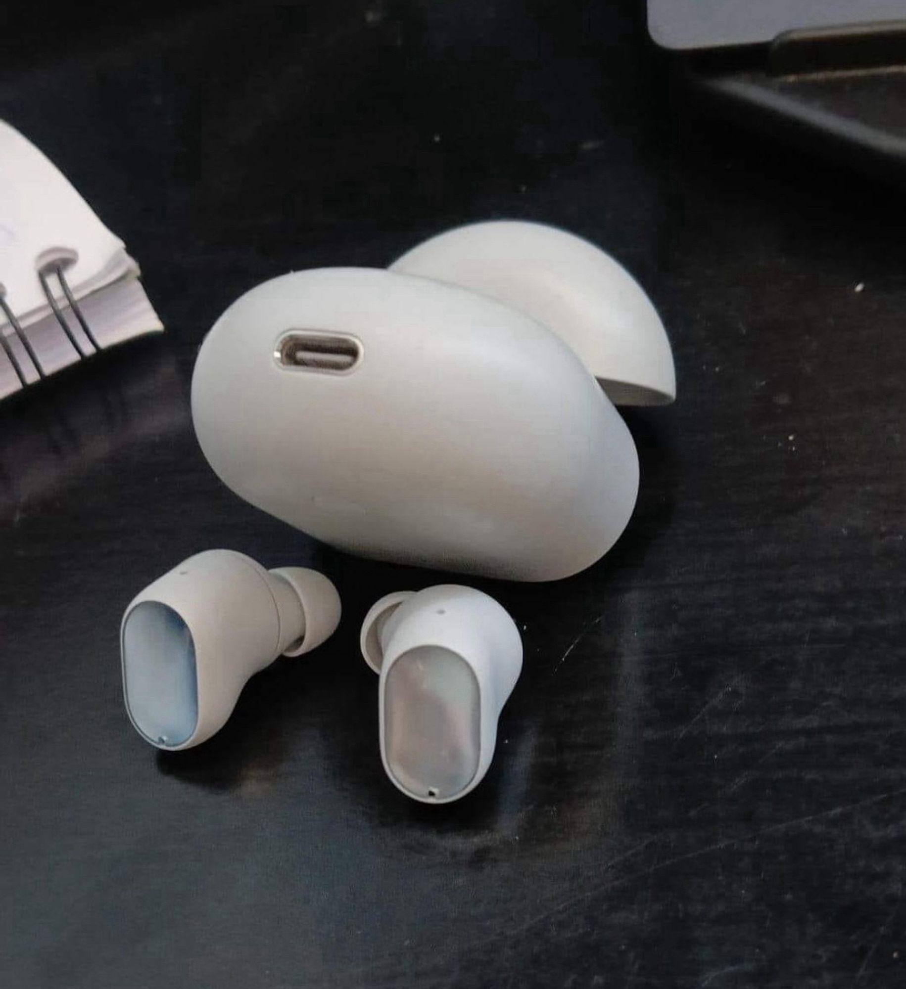 wireless headphones and their case posed in a way that looks like the headphones are bending over to get fucked doggie style. the usb3 charger port is the butthole