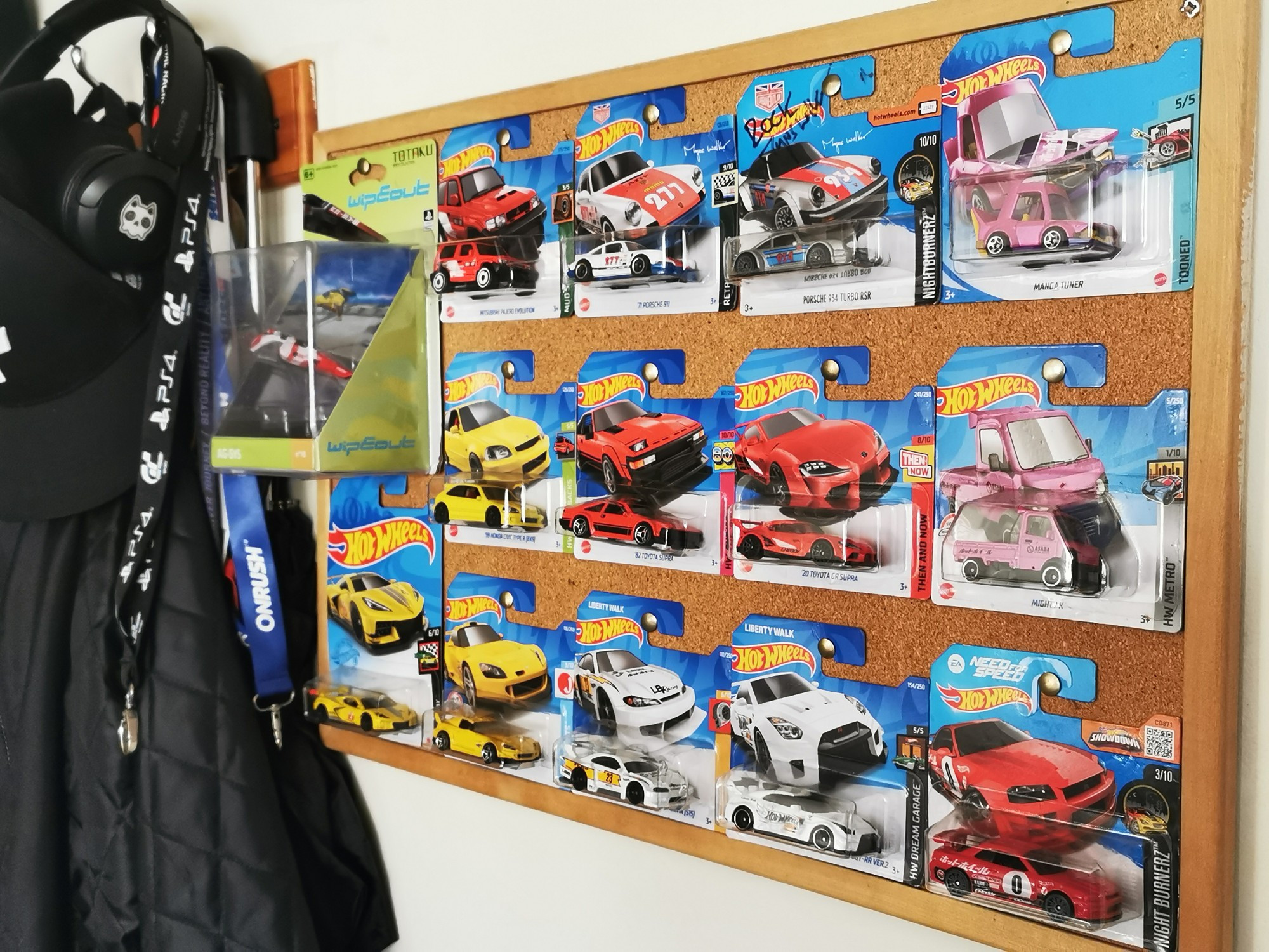 Photo of several hot wheels diecast models pitted to a wall board 