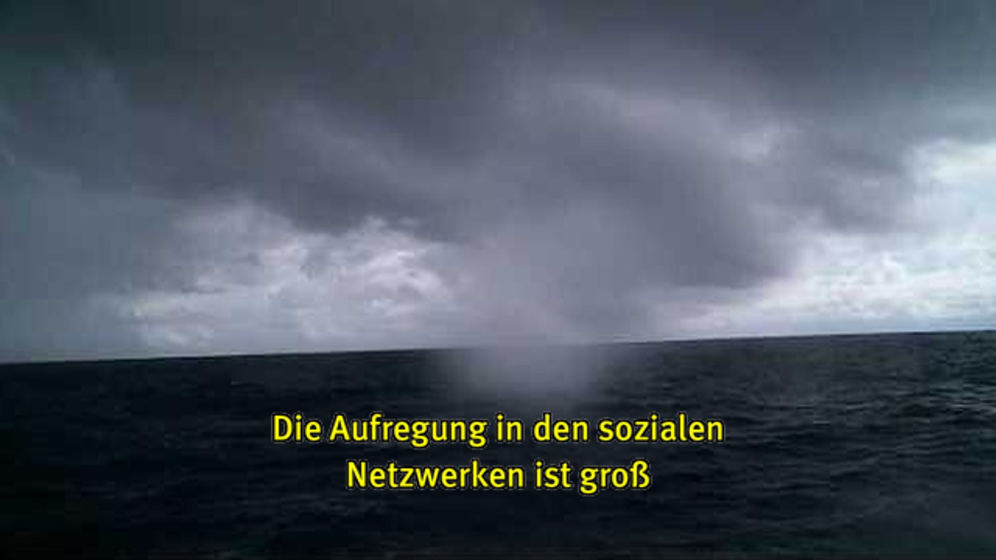 Webcam-Foto vom Meer, untertitelt mit gelber Schrift: "Die Aufregung in den sozialen Netzwerken ist groß"