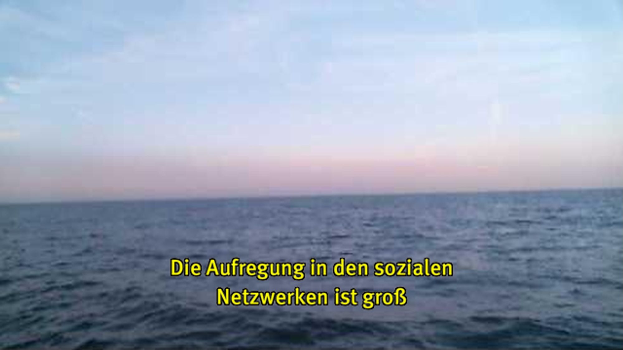 Webcam-Foto vom Meer, untertitelt mit gelber Schrift: "Die Aufregung in den sozialen Netzwerken ist groß"