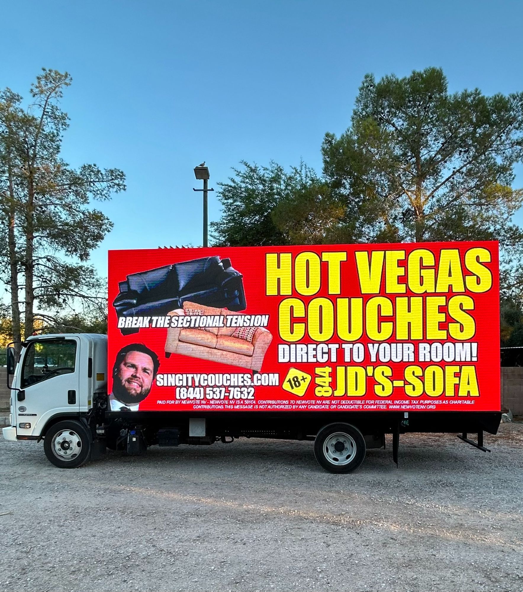 billboard truck that says "hot vegas couches direct to your room!" "break the sectional tension" with two couches and a photo of JD vance. there is also a phone number 844-JD's-SOFA or 844-537-7632 and an 18+ logo and sincitycouches.com