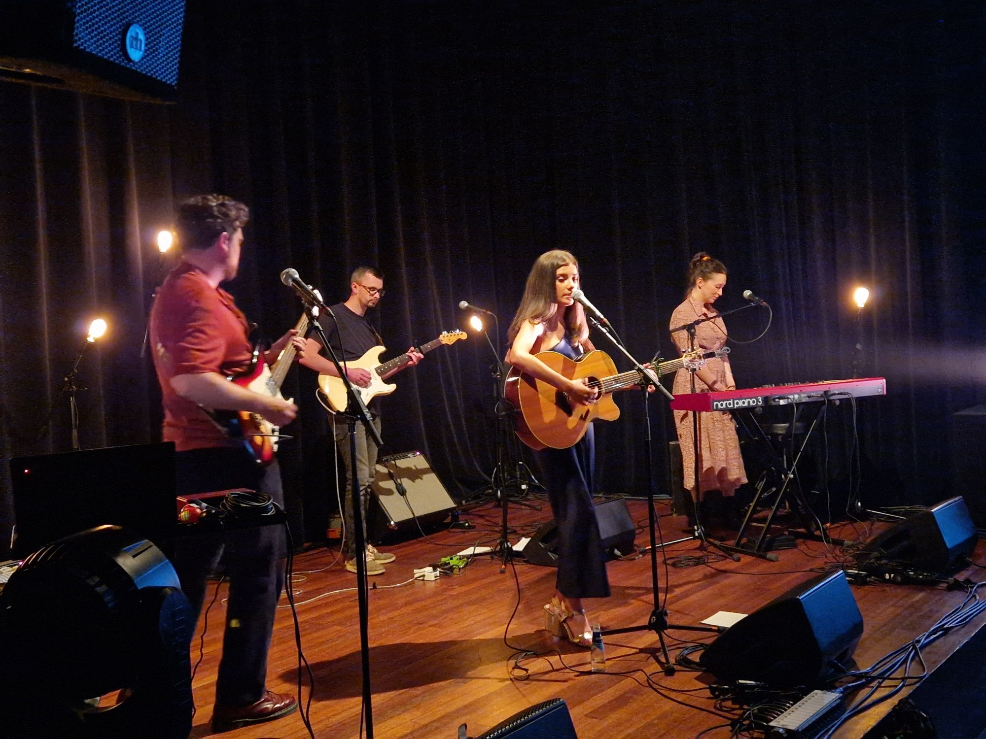 Image of four people of the band IMLÉ on stage at Tivoli Vredenburg