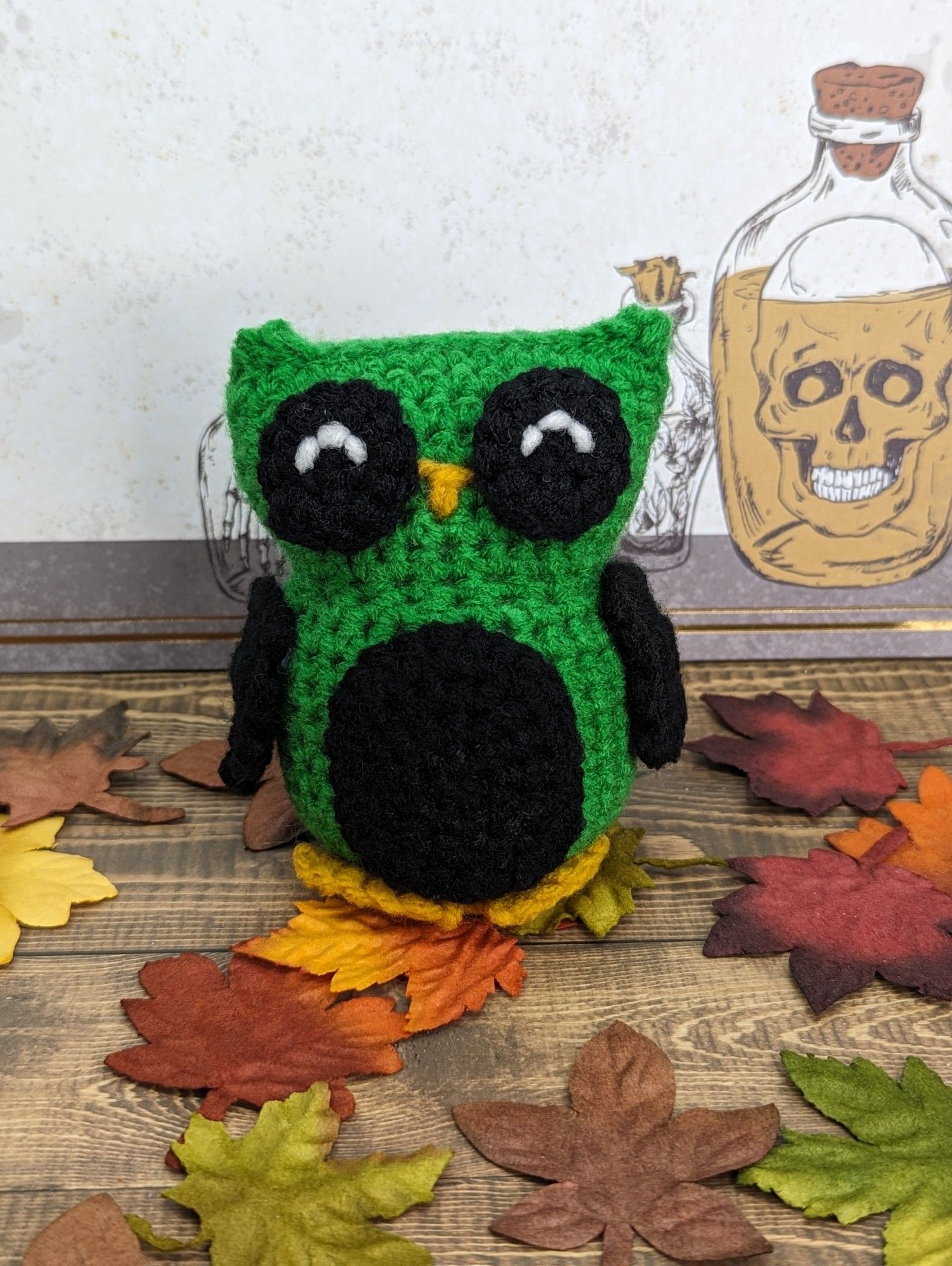 A green and black crocheted owl