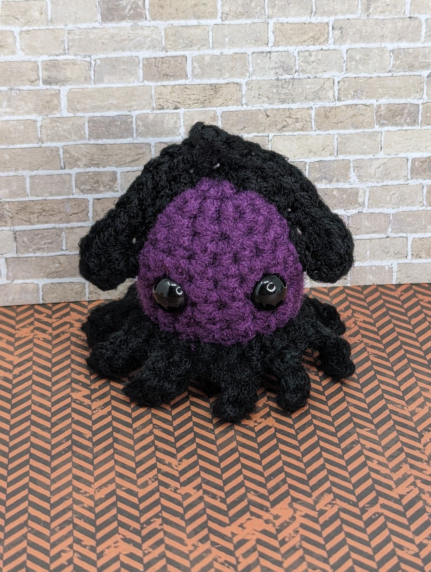 A purple and black crocheted squid