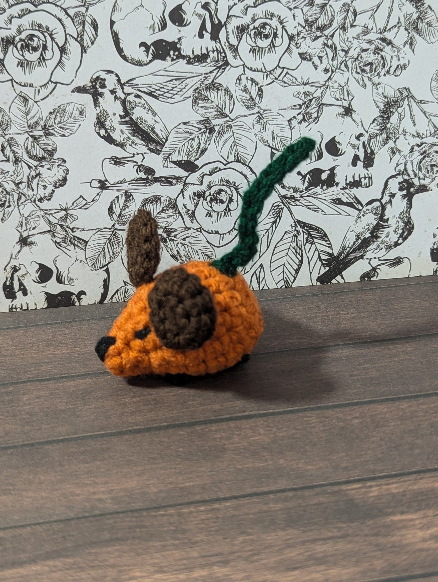 A tiny pumpkin themed crocheted mouse