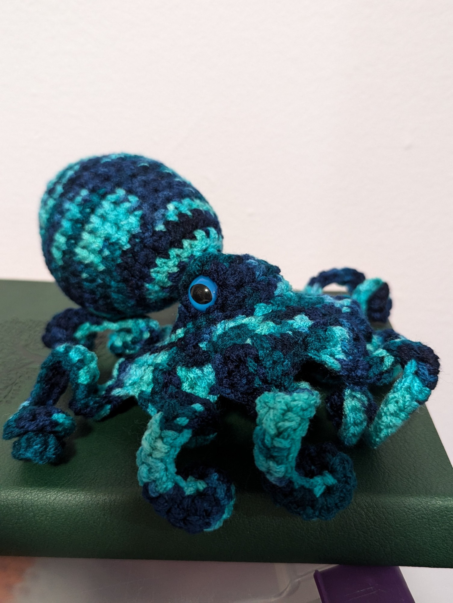 A blue and teal variegated crocheted octopus