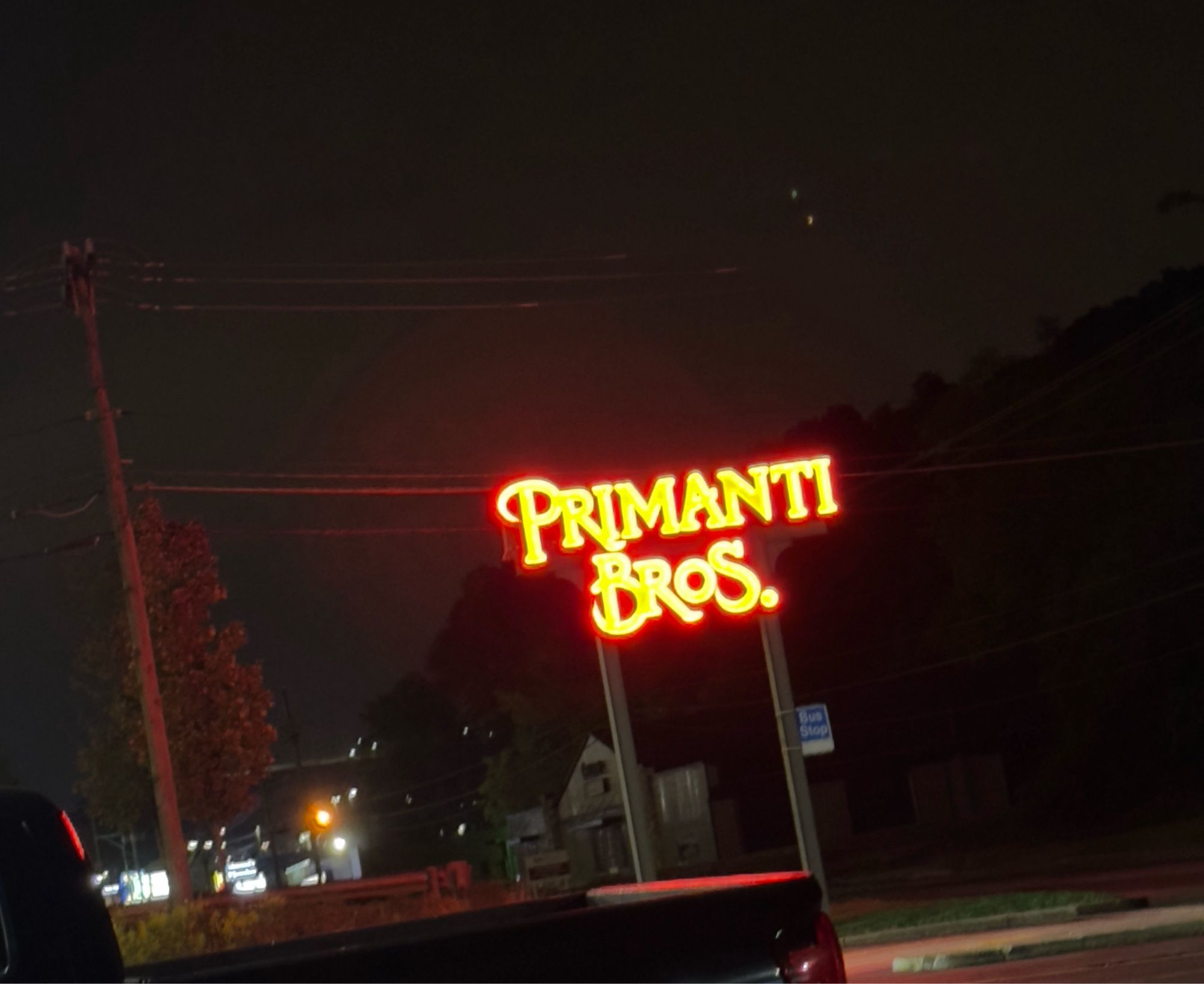 Neon red Primanti Bros restaurant sign against black night sky