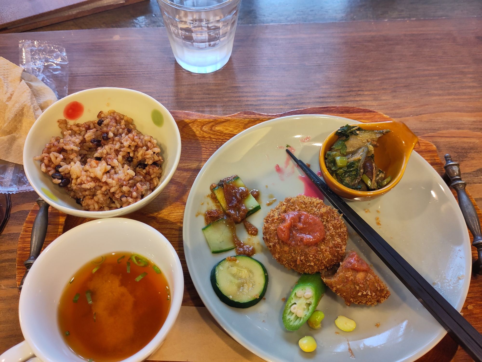 Ein Tablet mit Misosuppe, Fermentierten Naturreis (mega lecker) und eingelegtem Gemüse (Gurke, Okra und Zucchini) mit zwei veganen Kroquetten.