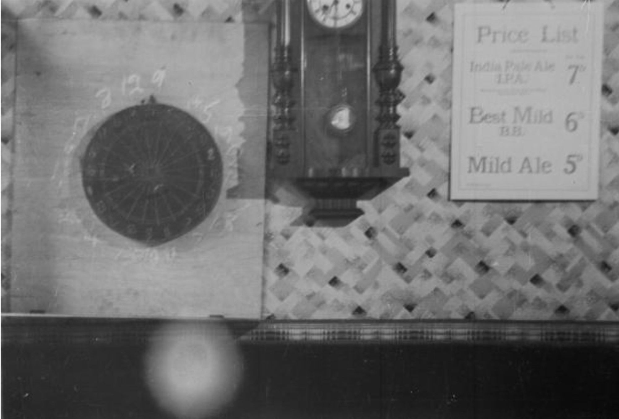 Photo source: Bolton Museum’s Humphrey Spender Worktown Collection. Archival photograph of a darts board, a hanging clock, and price list for ale.