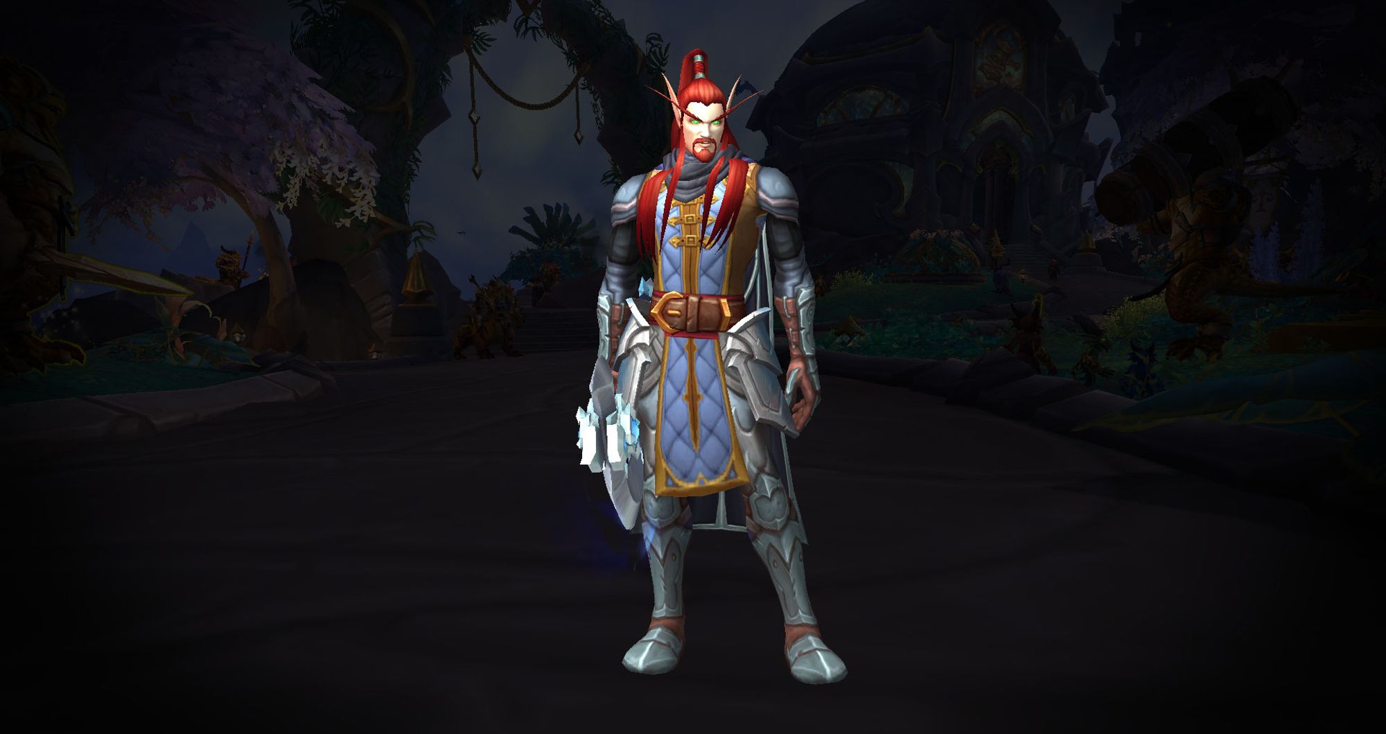 A World of Warcraft Blood Elf character sporting a silver and black suit of armor with a padded blue and golden tabard. He is red-haired and is standing looking at the camera, in a relaxed way