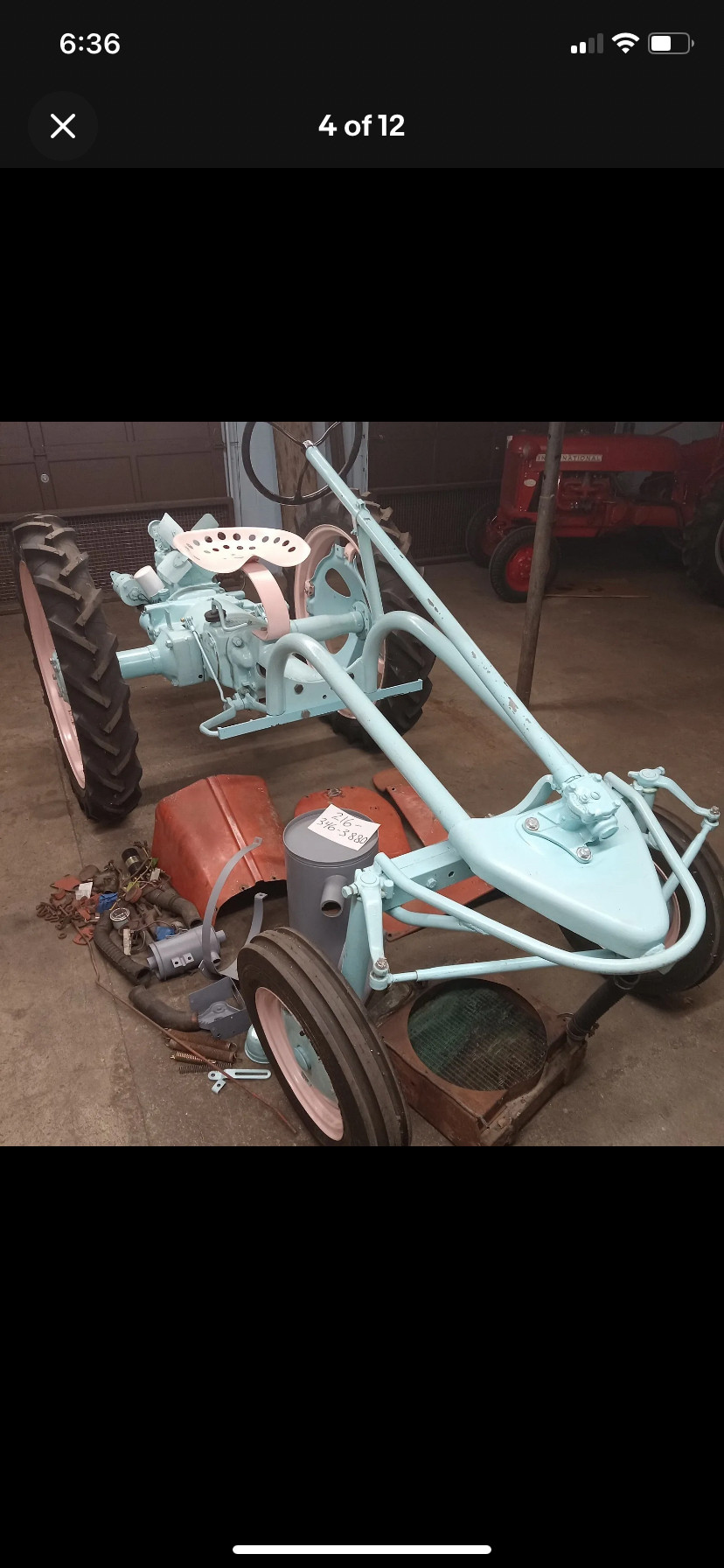 Partially assembled Allis Chalmers model G tractor painted pink and blue.